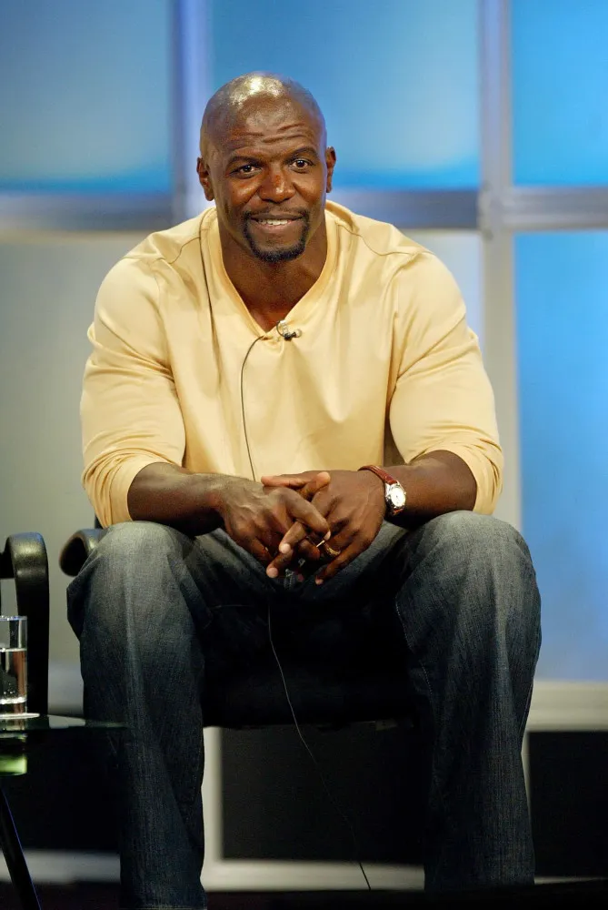 O ator Terry Crews mostrando seus músculos famosos, com um sorriso no rosto.