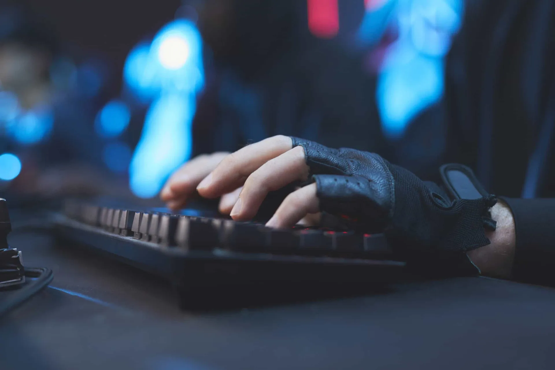 Pessoa digitando em um laptop usando luvas sem dedos para manter as mãos aquecidas.