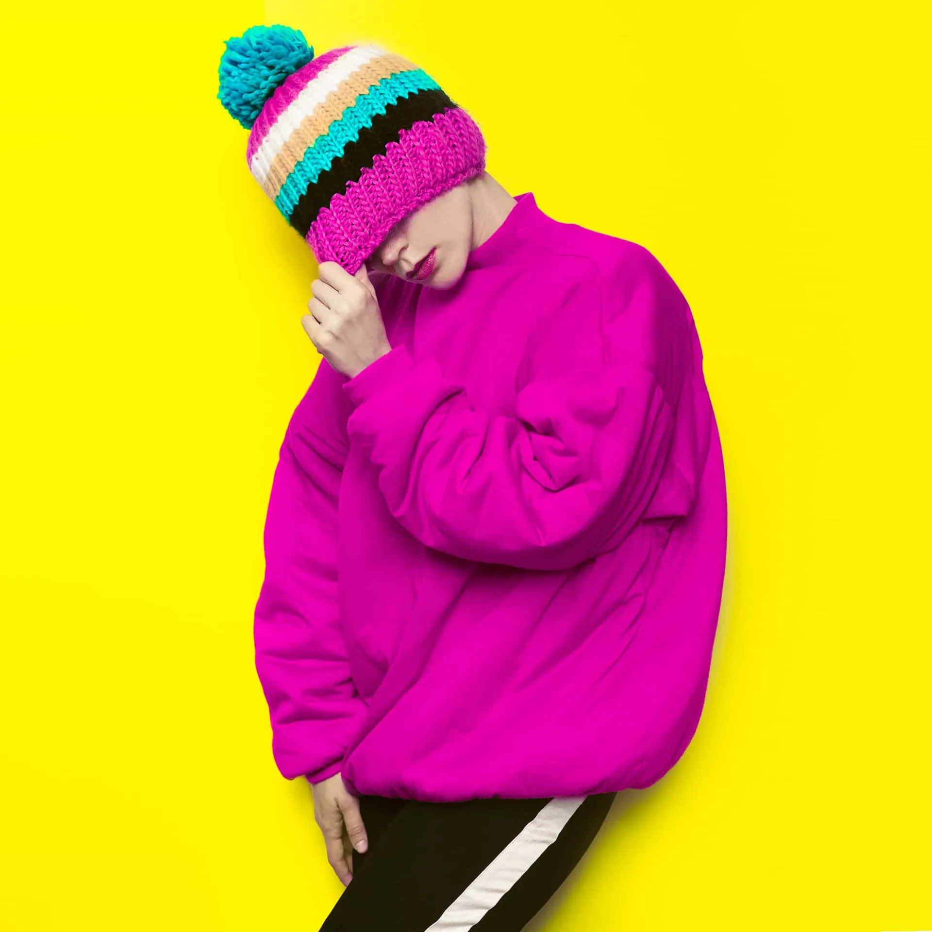 Mulher usando um gorro de lã bem grosso e quente, com o rosto protegido do frio intenso.