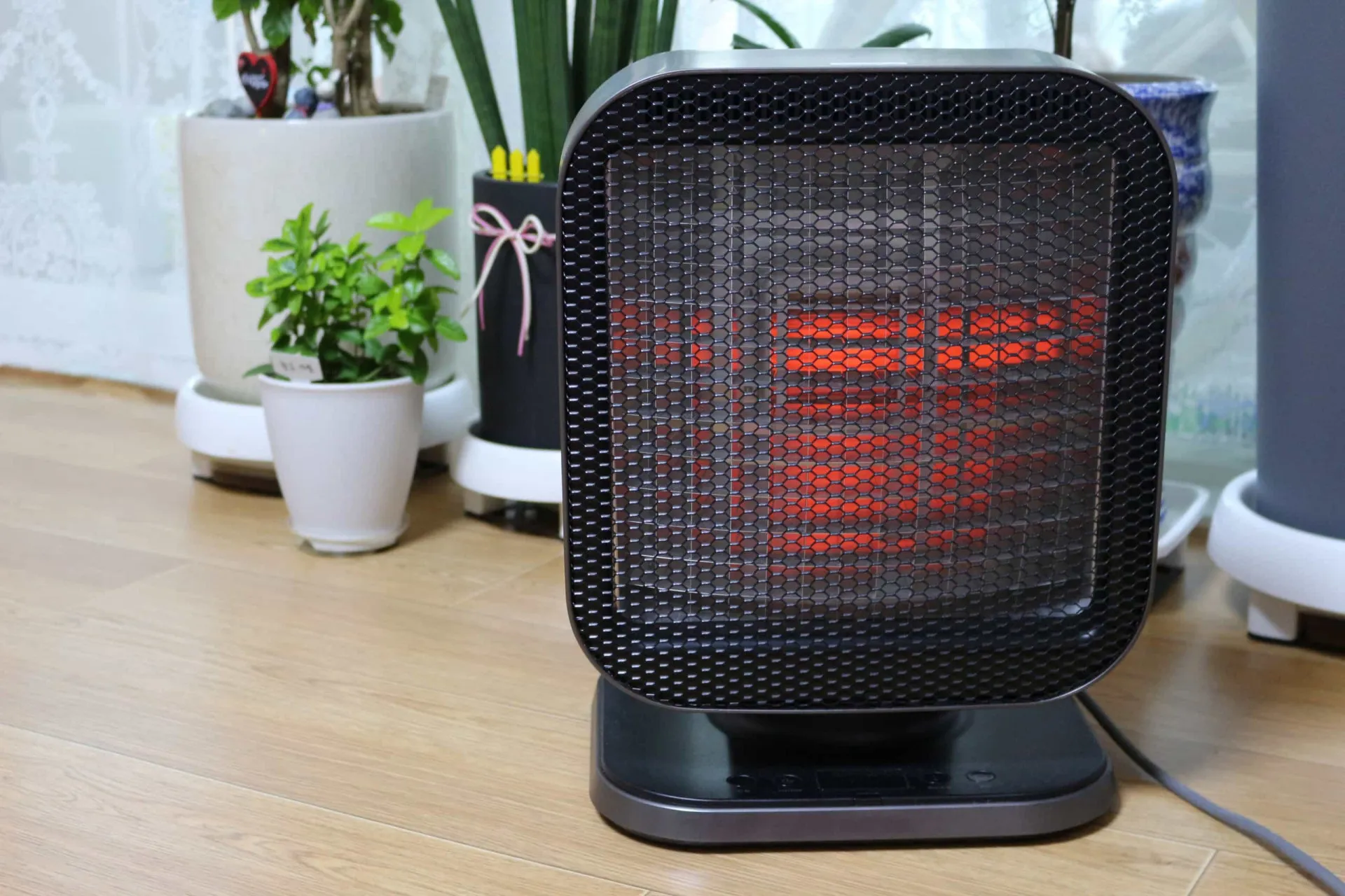 Um aquecedor de ambiente portátil elétrico ligado em uma sala, irradiando calor para o espaço.