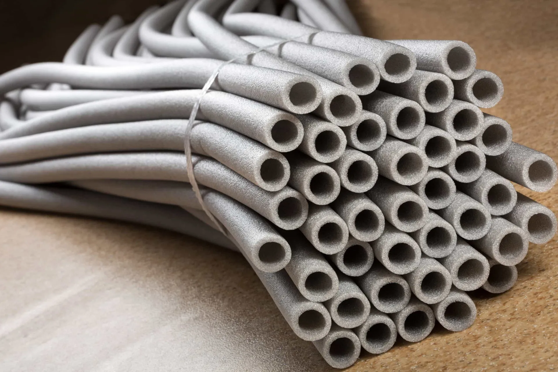 Tubos de isolamento de espuma sendo preparados para serem cortados e adaptados na base de uma porta.