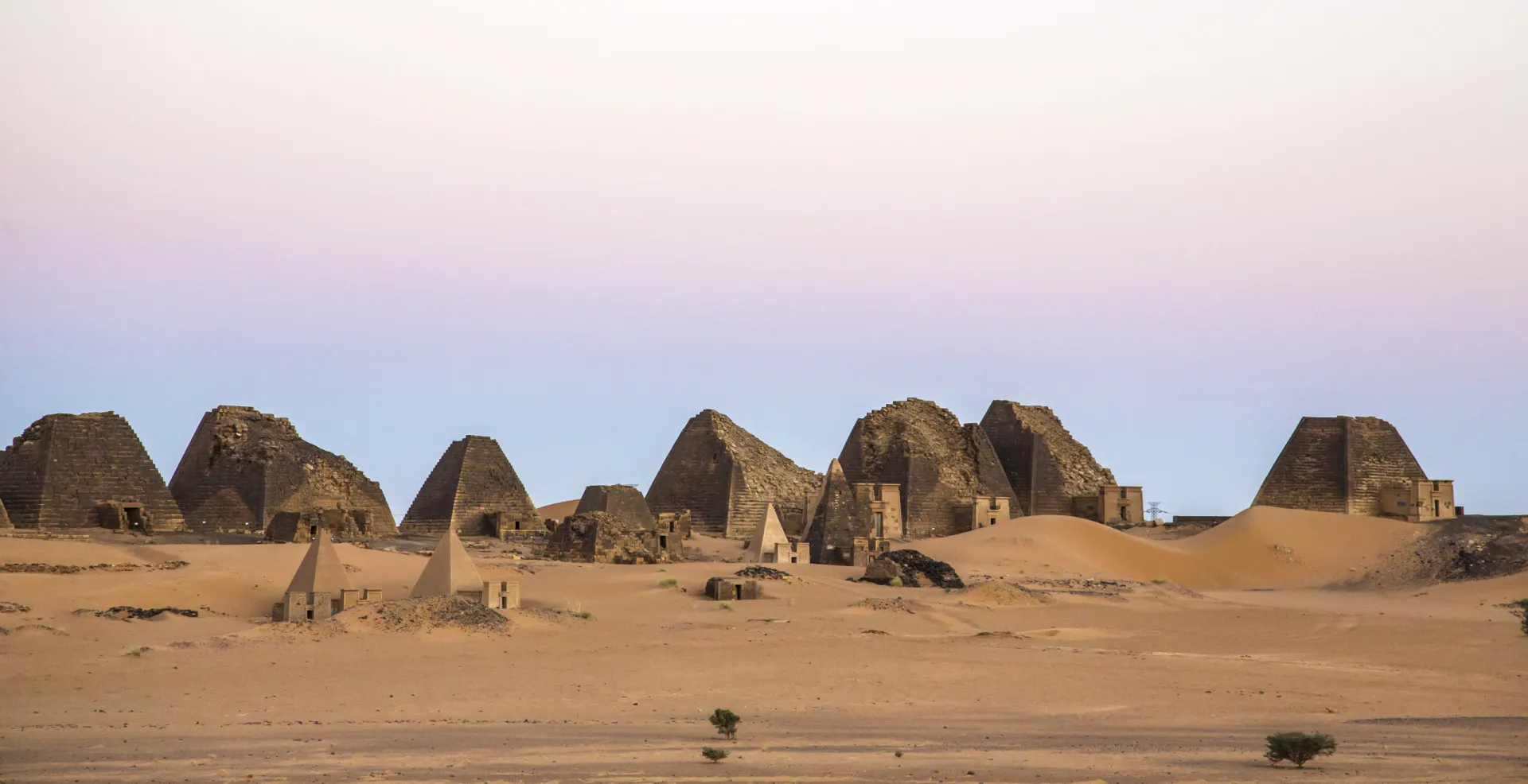 Paisagem do deserto do Sudão ao pôr do sol, evocando paz e liberdade.