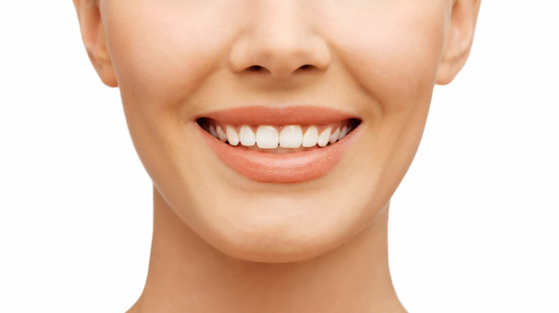 Uma pessoa sorrindo e mostrando dentes brancos enquanto segura uma escova de dentes.