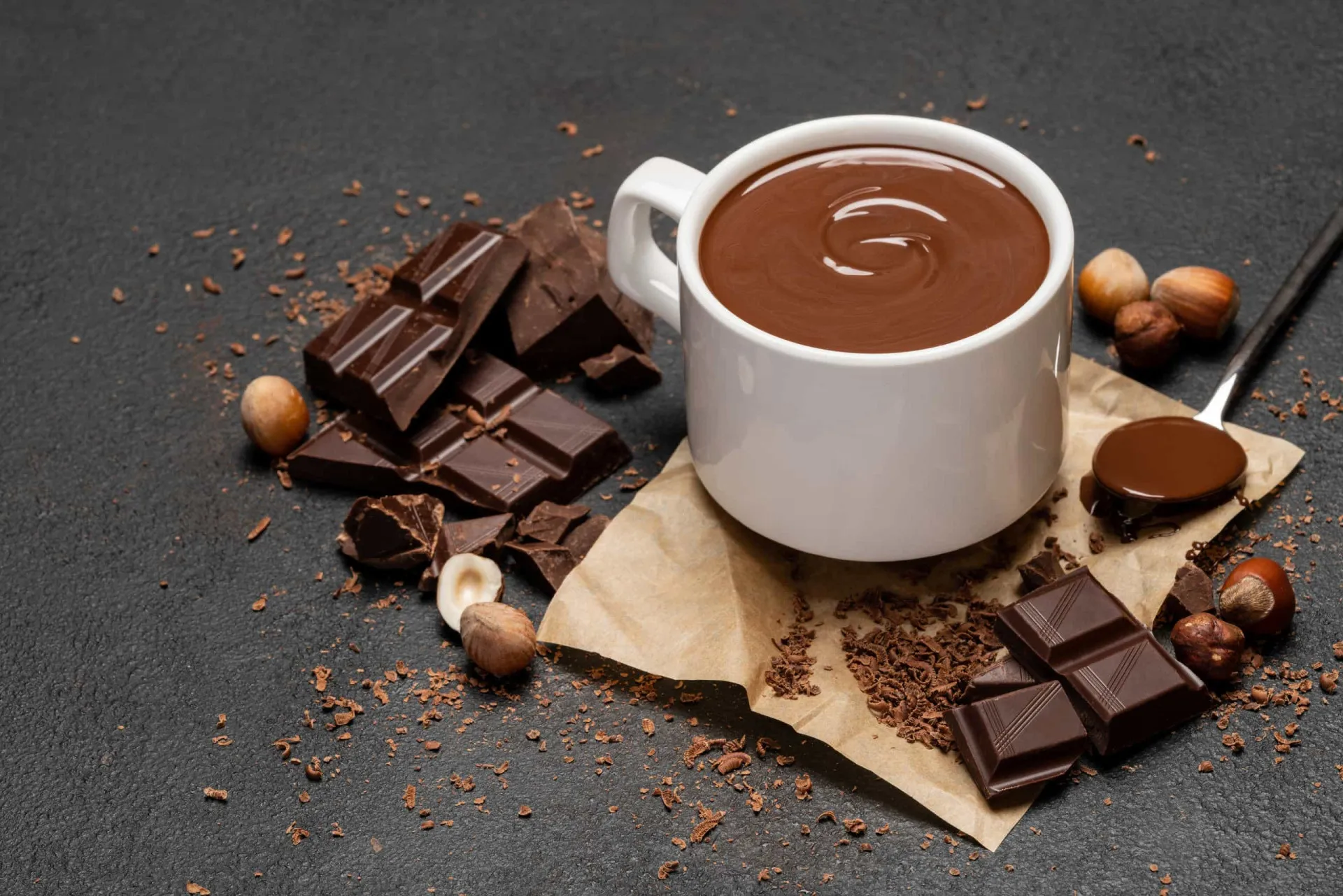Pedaços de chocolate ao leite e amargo quebrados sobre uma superfície.