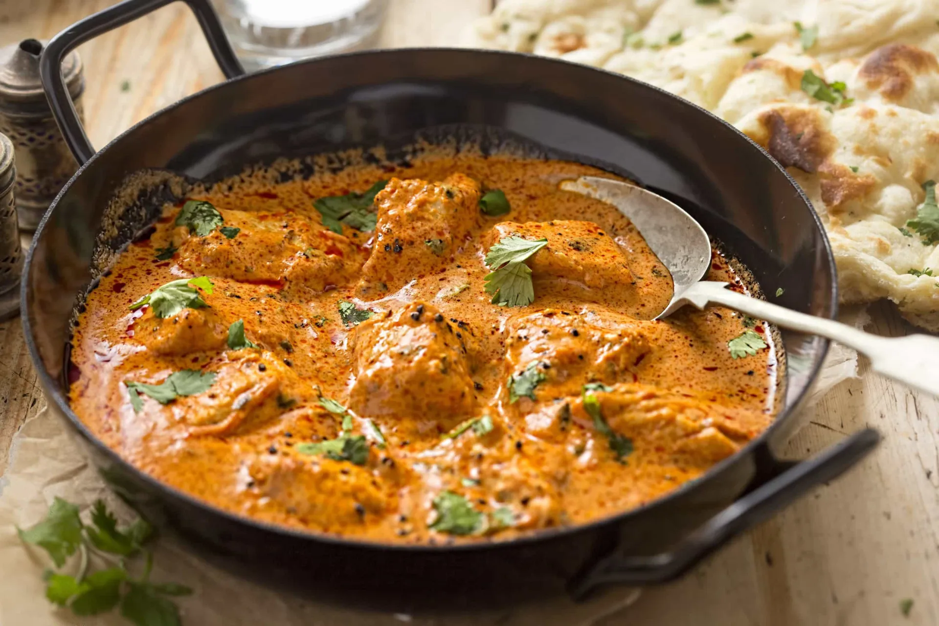 Um prato de curry amarelo intenso com frango e vegetais.