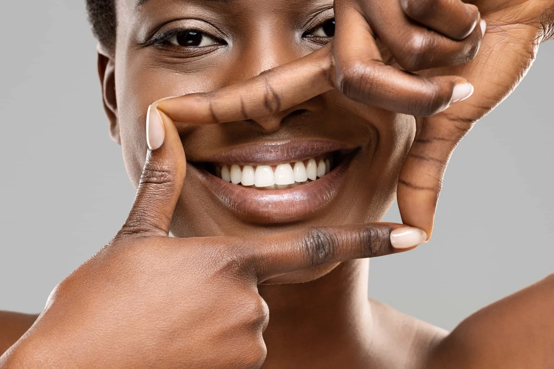 Comparação de um dente manchado ao lado de um dente coberto com uma faceta de porcelana branca e perfeita.