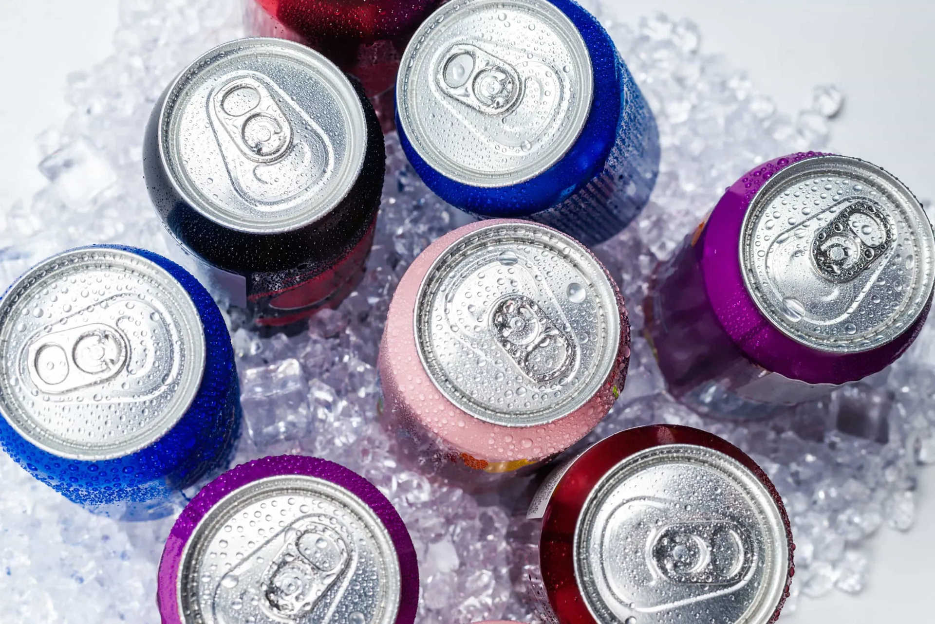 Garrafas coloridas de bebidas esportivas e latas de energéticos.