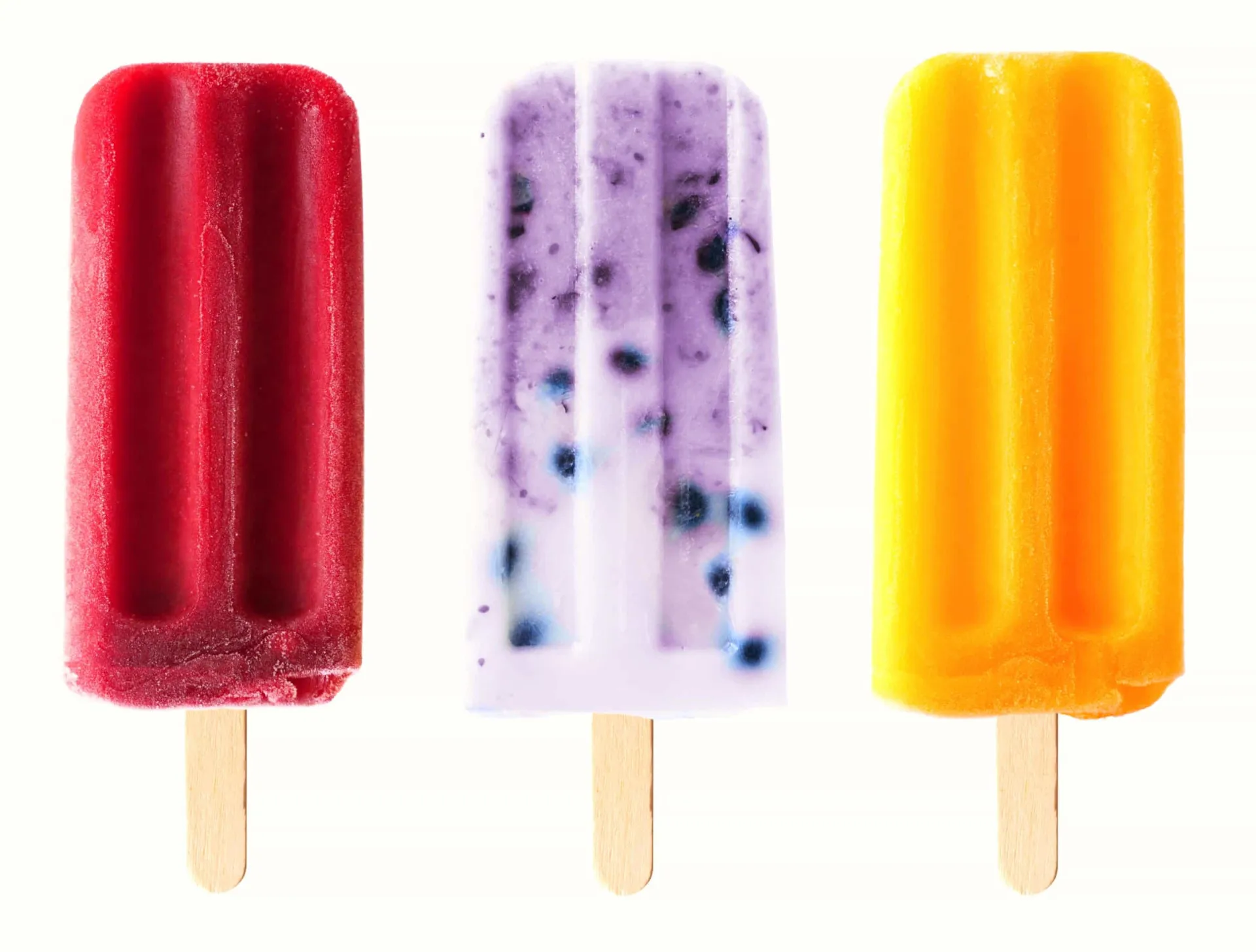Picolés de frutas coloridos, como uva e limão, derretendo.
