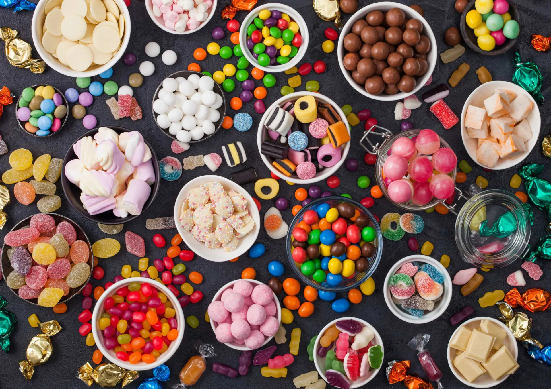 Uma variedade colorida de balas, pirulitos e doces diversos.