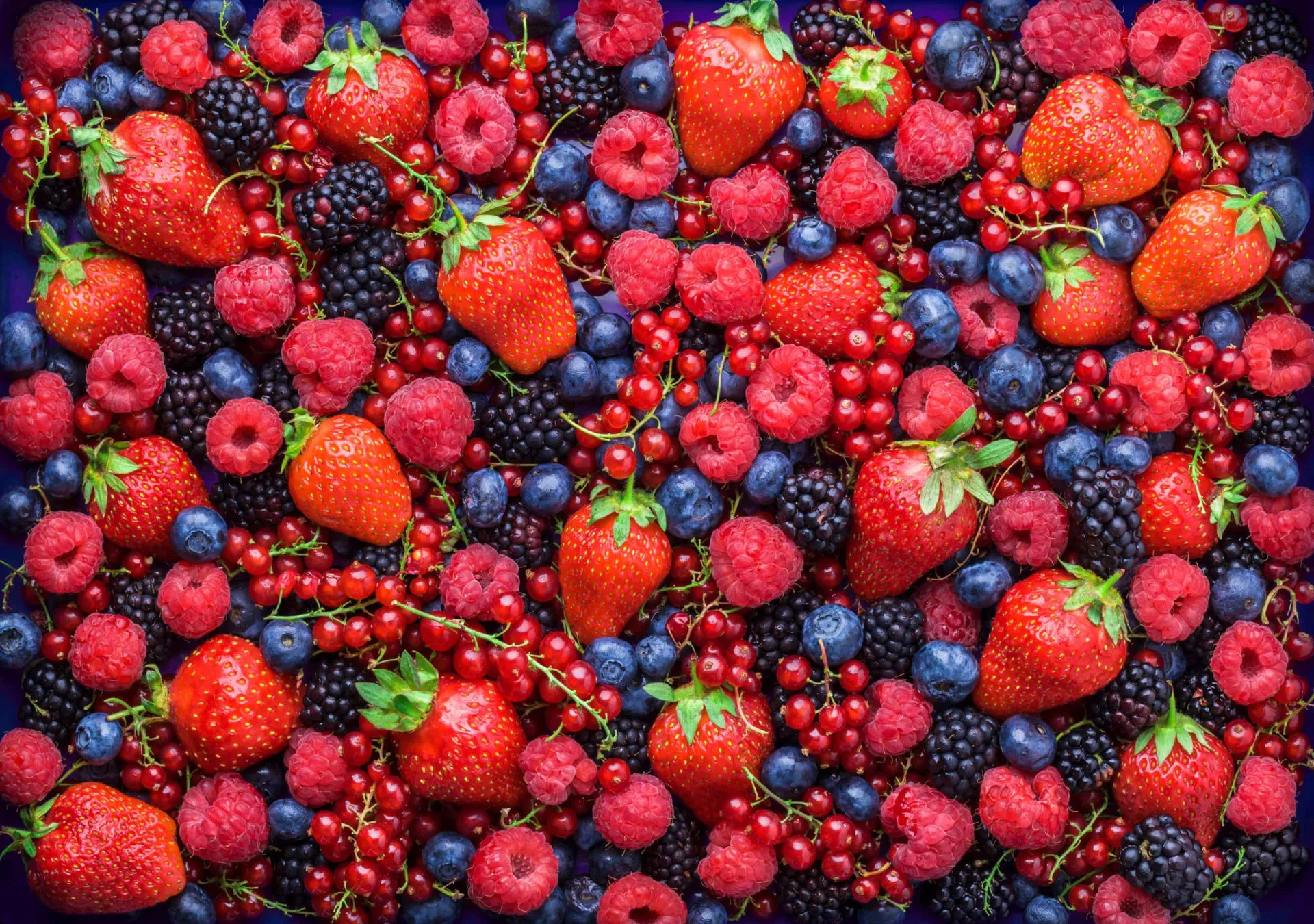 Uma tigela cheia de frutas vermelhas como mirtilos e framboesas.