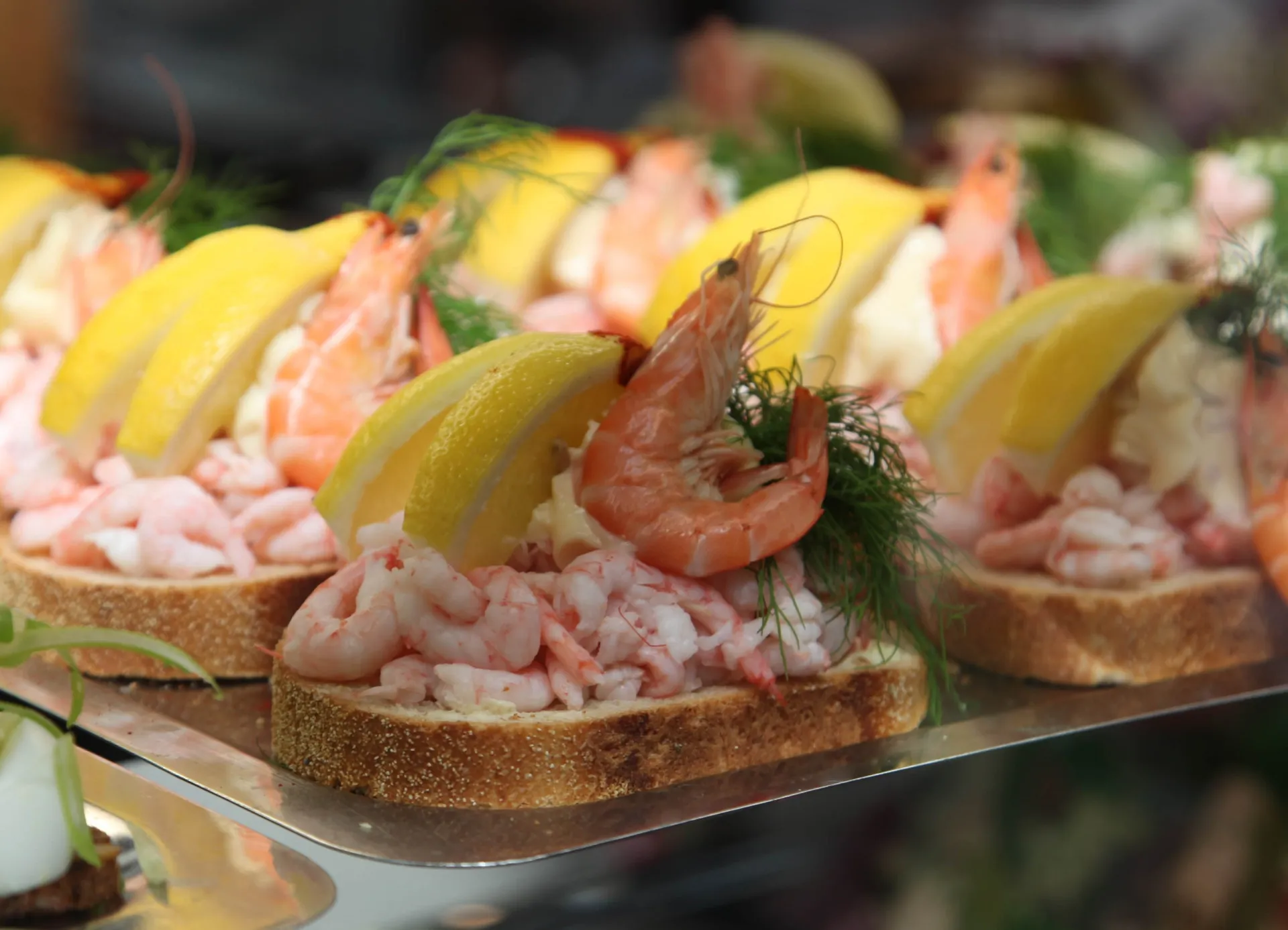 Um prato de smørrebrød dinamarquês, um sanduíche aberto com vários ingredientes coloridos e apetitosos.