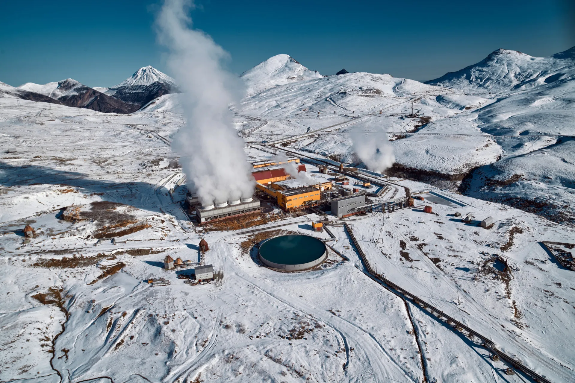 Vista aérea de uma usina de energia geotérmica na Islândia, com vapor subindo da paisagem vulcânica.