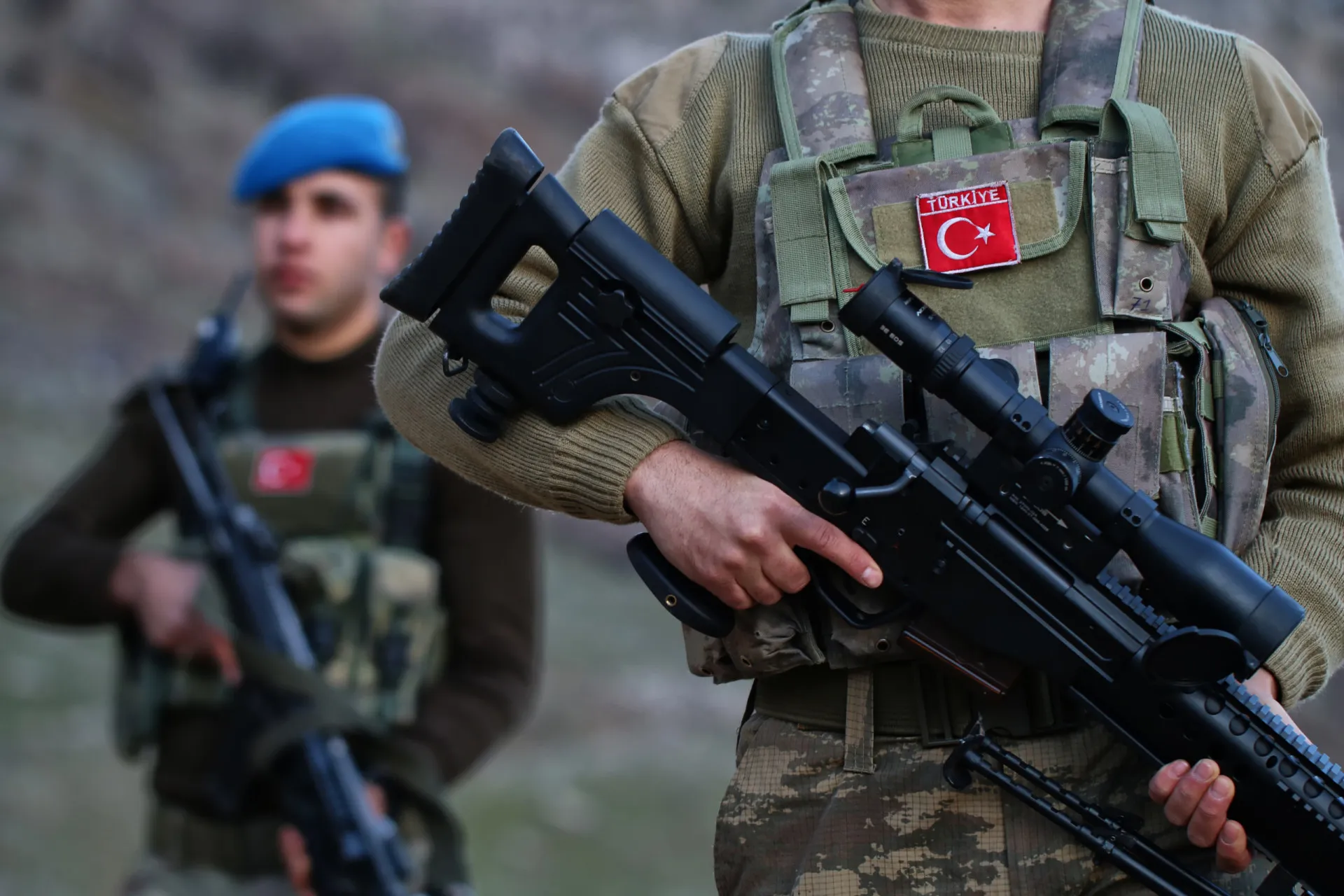 Bandeira da Turquia com soldados ao fundo, simbolizando a importância estratégica do país.