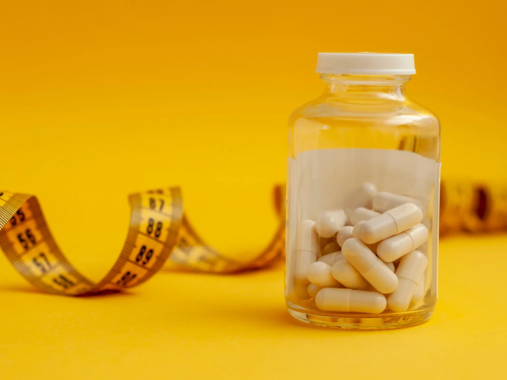 Vários tipos de medicamentos e tratamentos para obesidade dispostos sobre uma mesa.