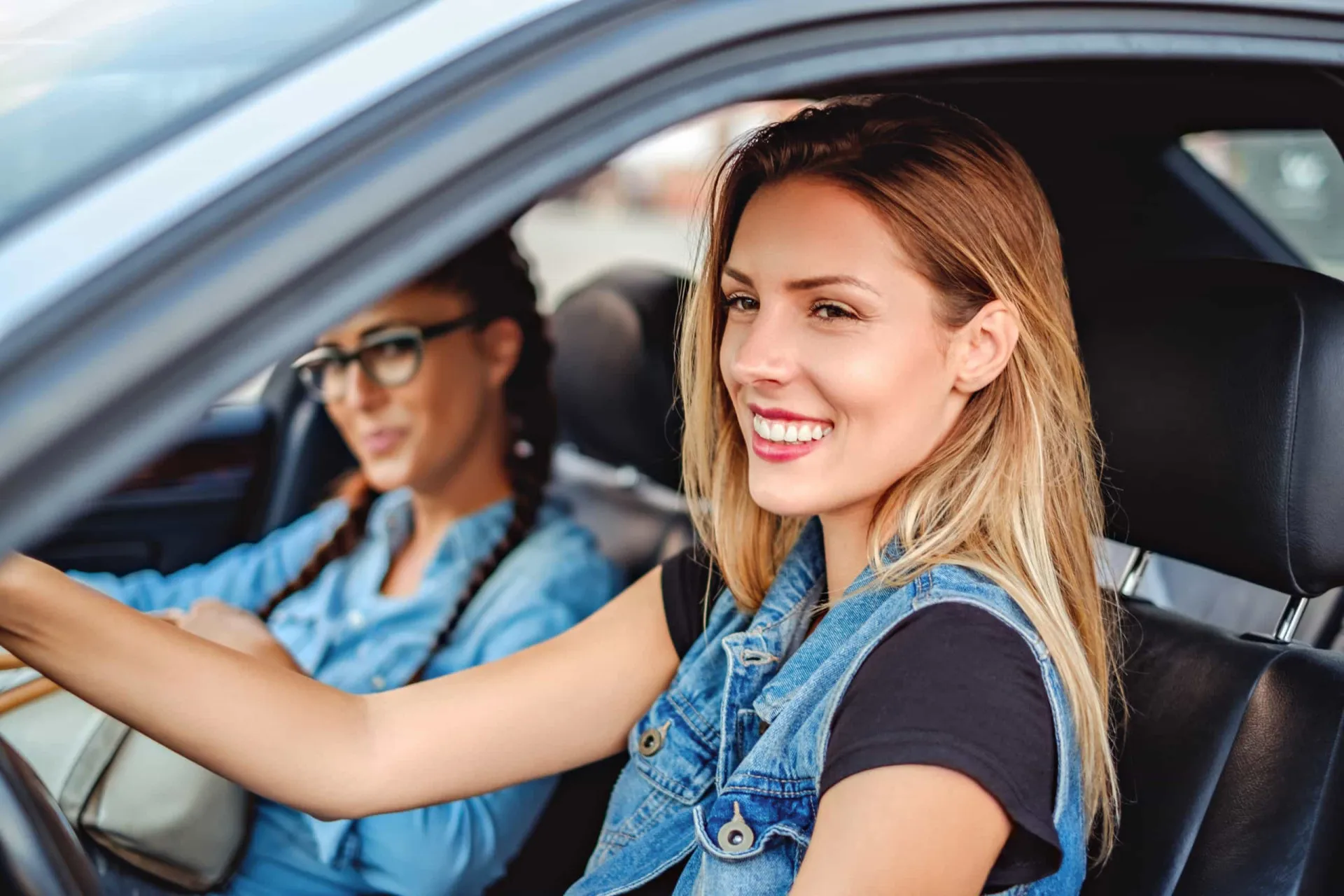 Dois carros parados lado a lado em um semáforo, sendo que um tentou ultrapassar o outro sem sucesso.