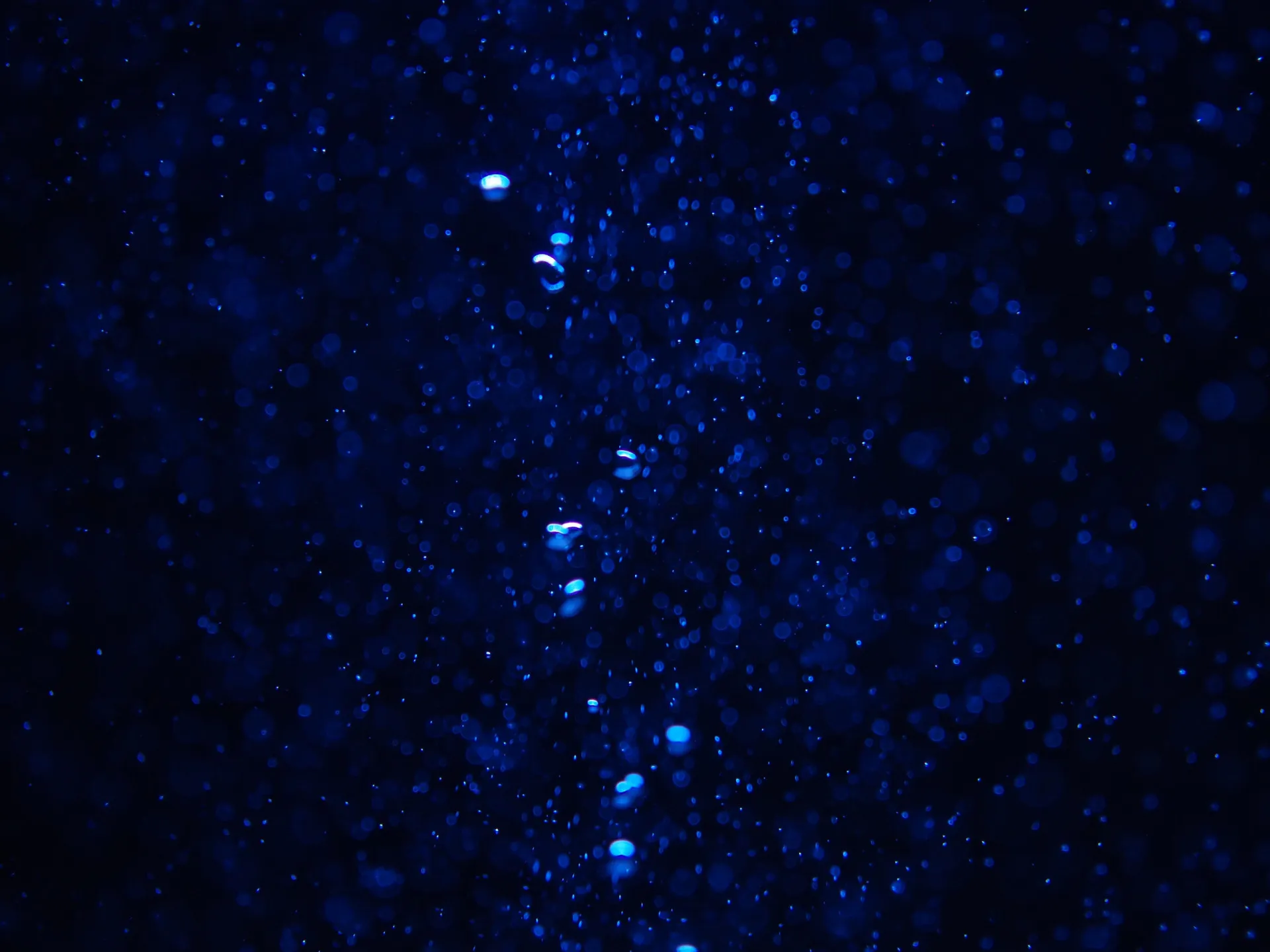 Uma silhueta de uma pessoa afundando nas profundezas escuras do oceano.