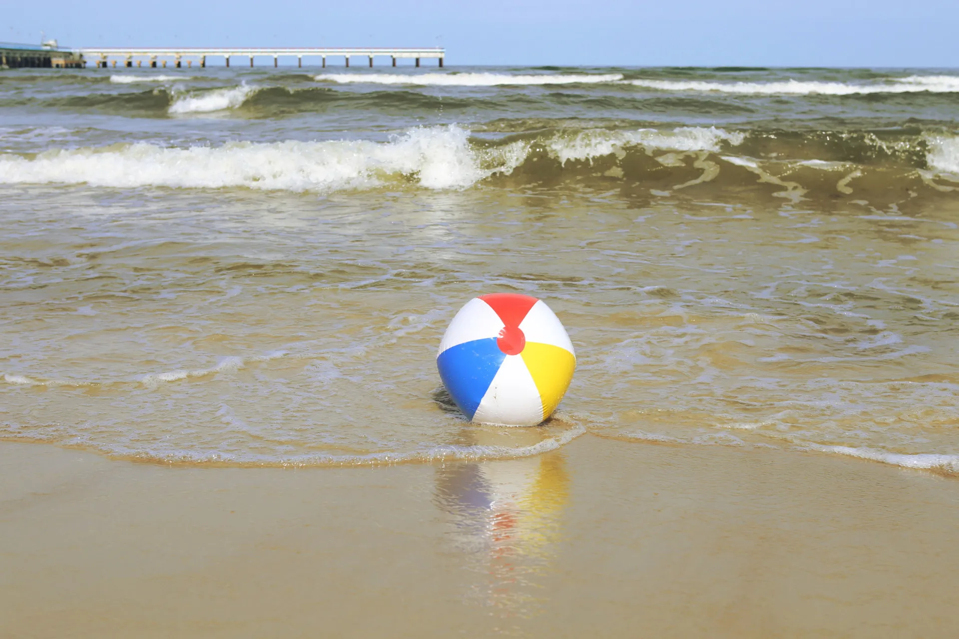 Uma bola de futebol murcha flutuando no mar, representando um objeto inusitado de salvação.
