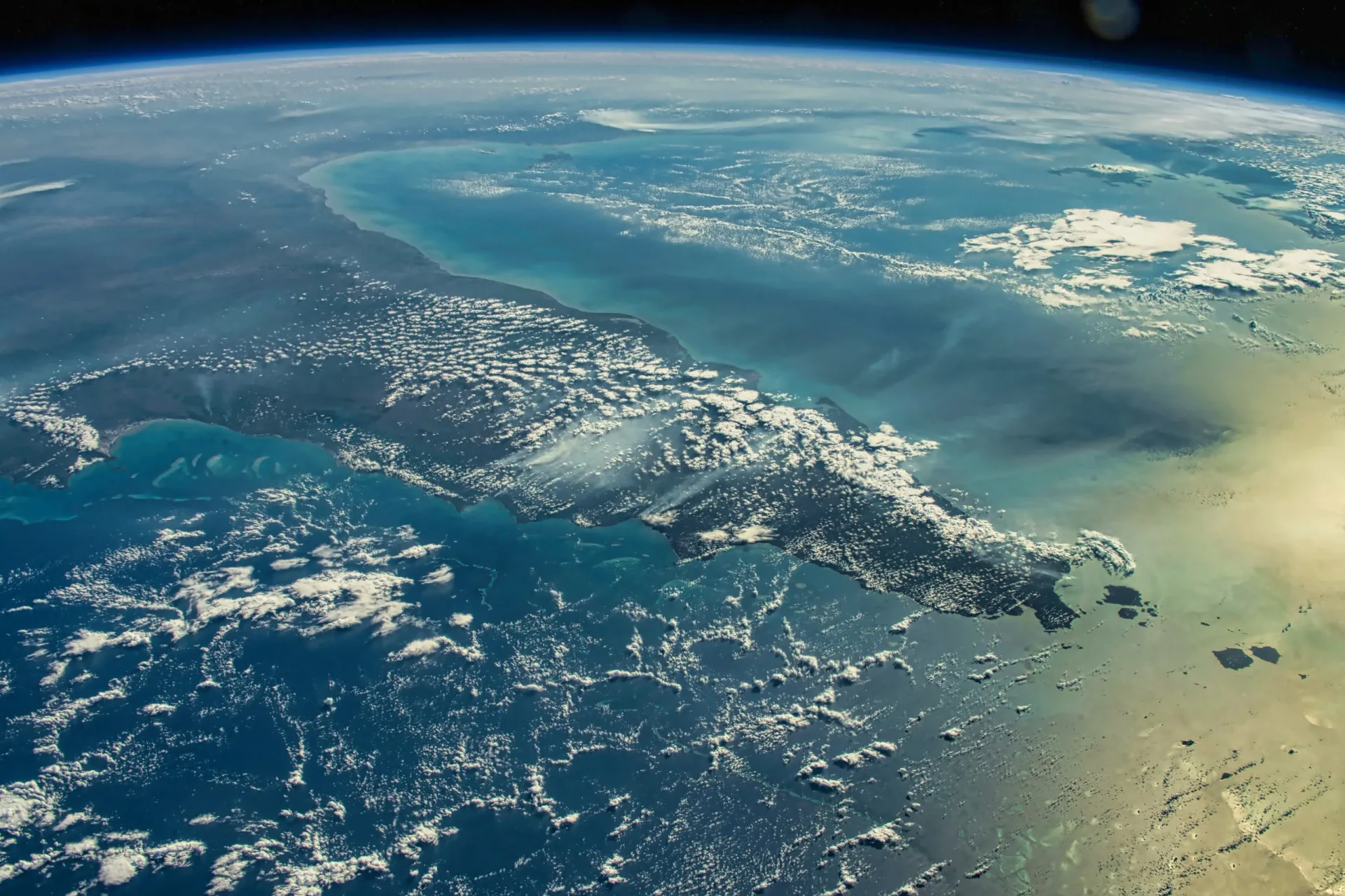 Visão ampla do oceano aberto, com o sol se pondo no horizonte, enfatizando sua imensidão.