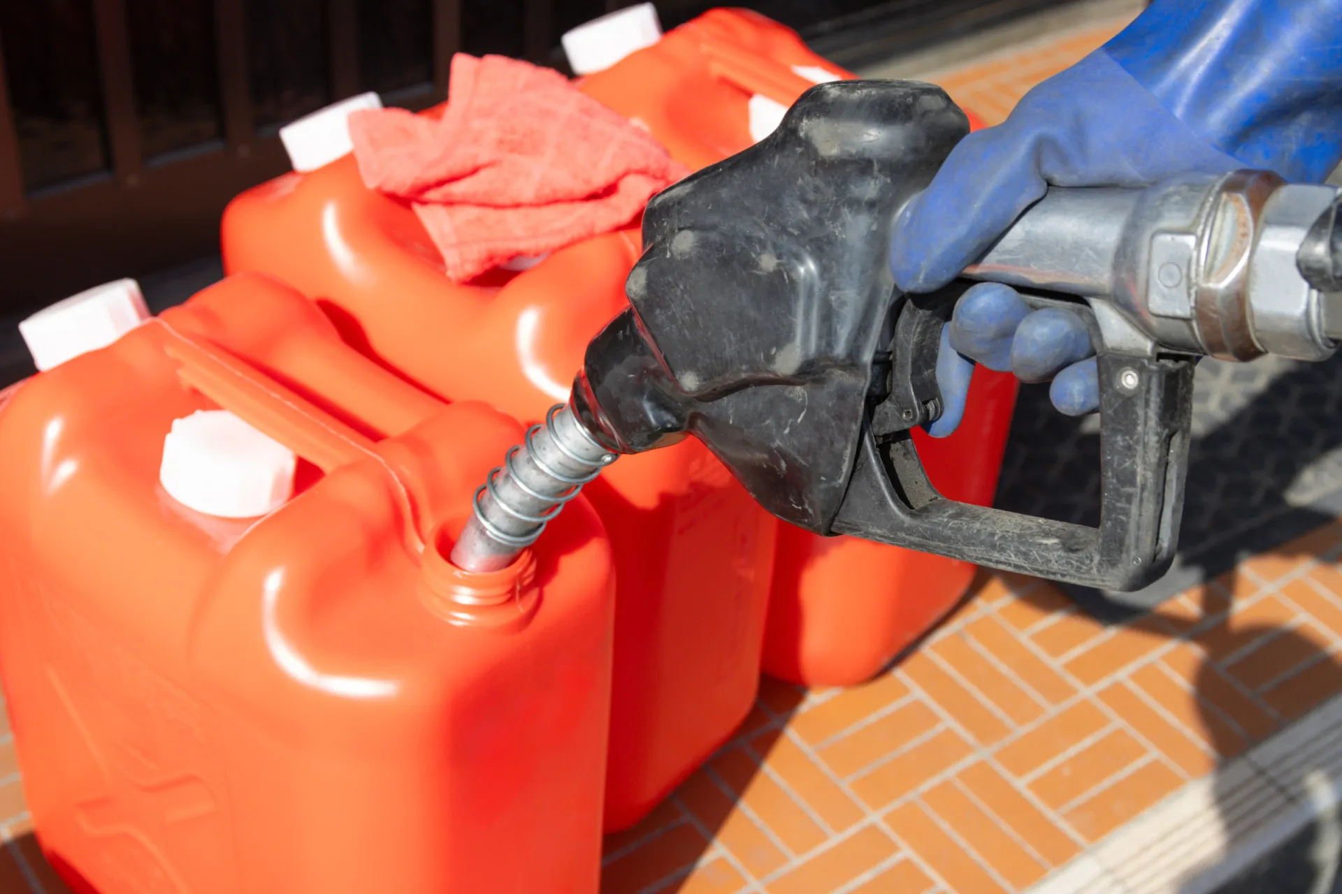 Galões de querosene e gasolina com um grande sinal de perigo.