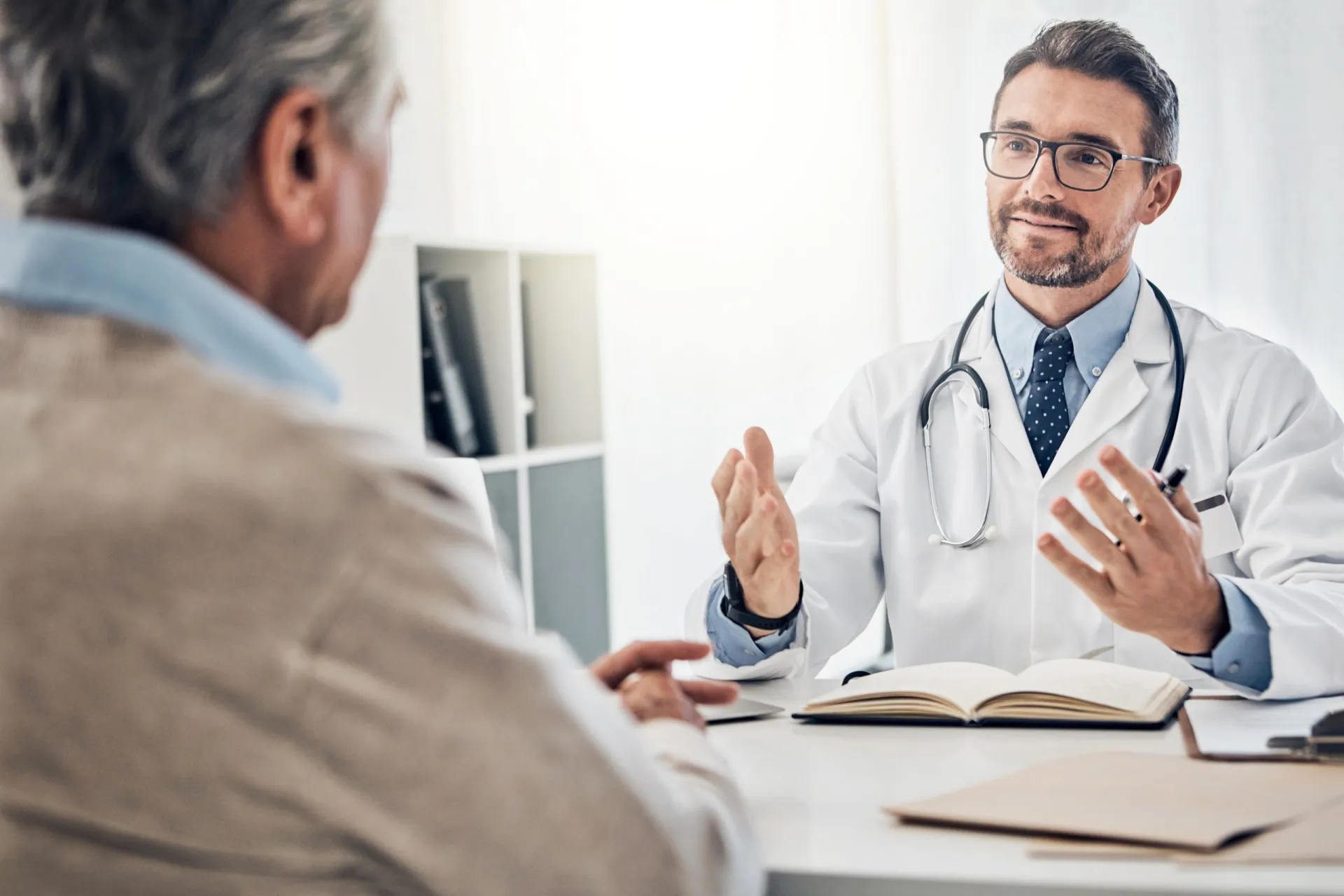 Paciente fazendo anotações em um caderno durante uma consulta médica para não esquecer as orientações.