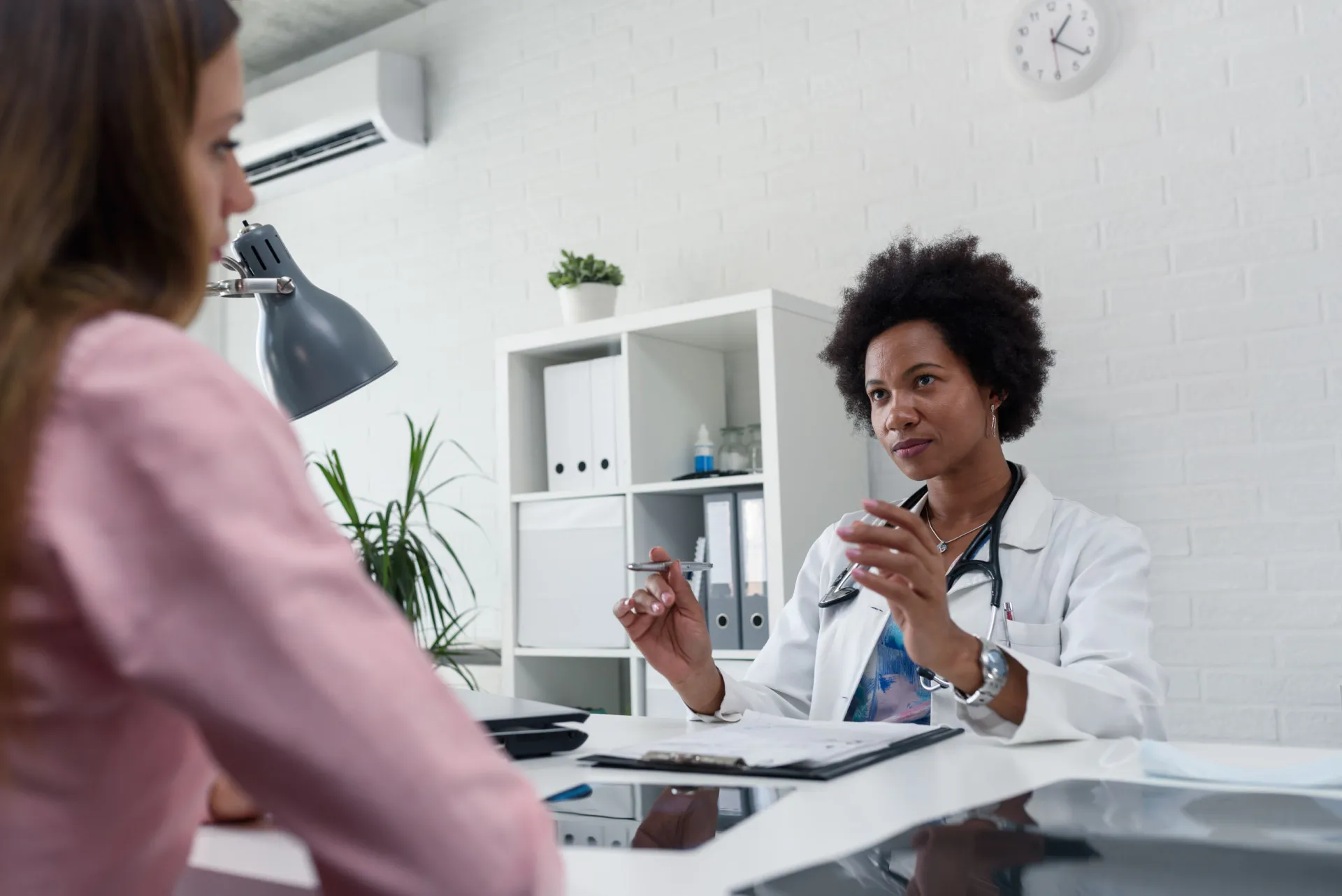 Médico auscultando os pulmões de um paciente com um estetoscópio em um consultório.