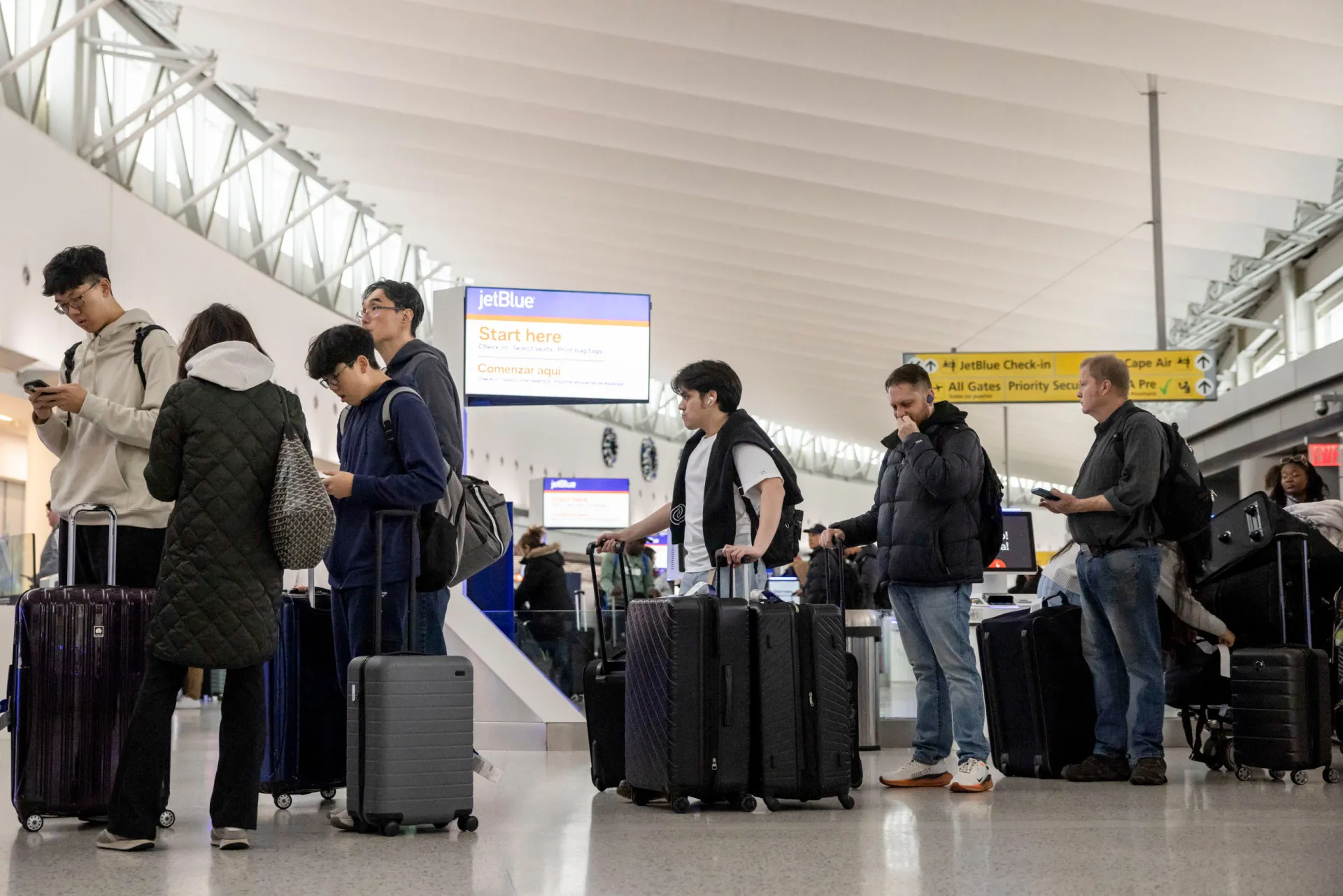 Placa de boas-vindas em um aeroporto com diversas bandeiras, mas com um tom de alerta.