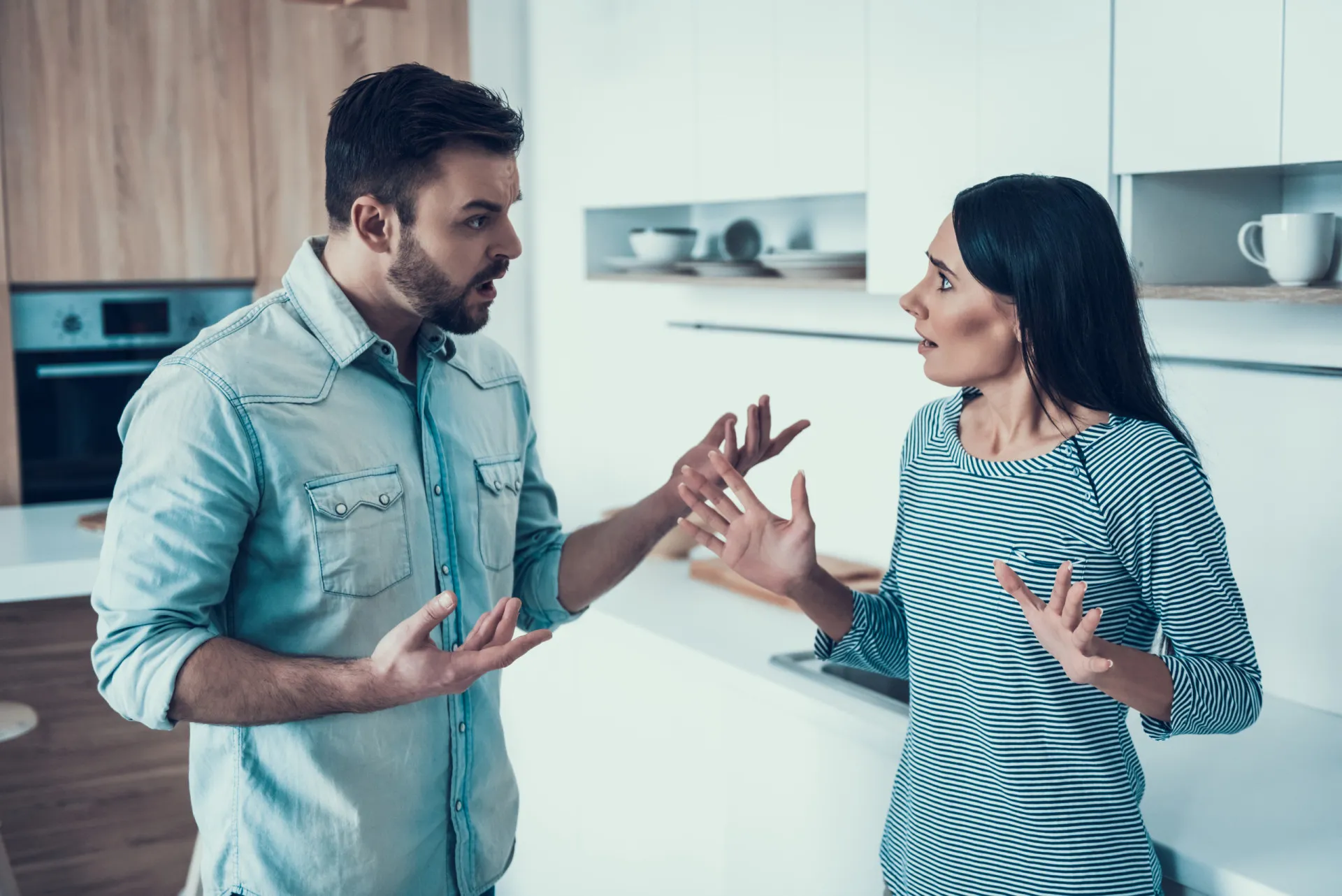 Casal em meio a um ambiente caótico e bagunçado, mas parecendo acostumado com a desordem.