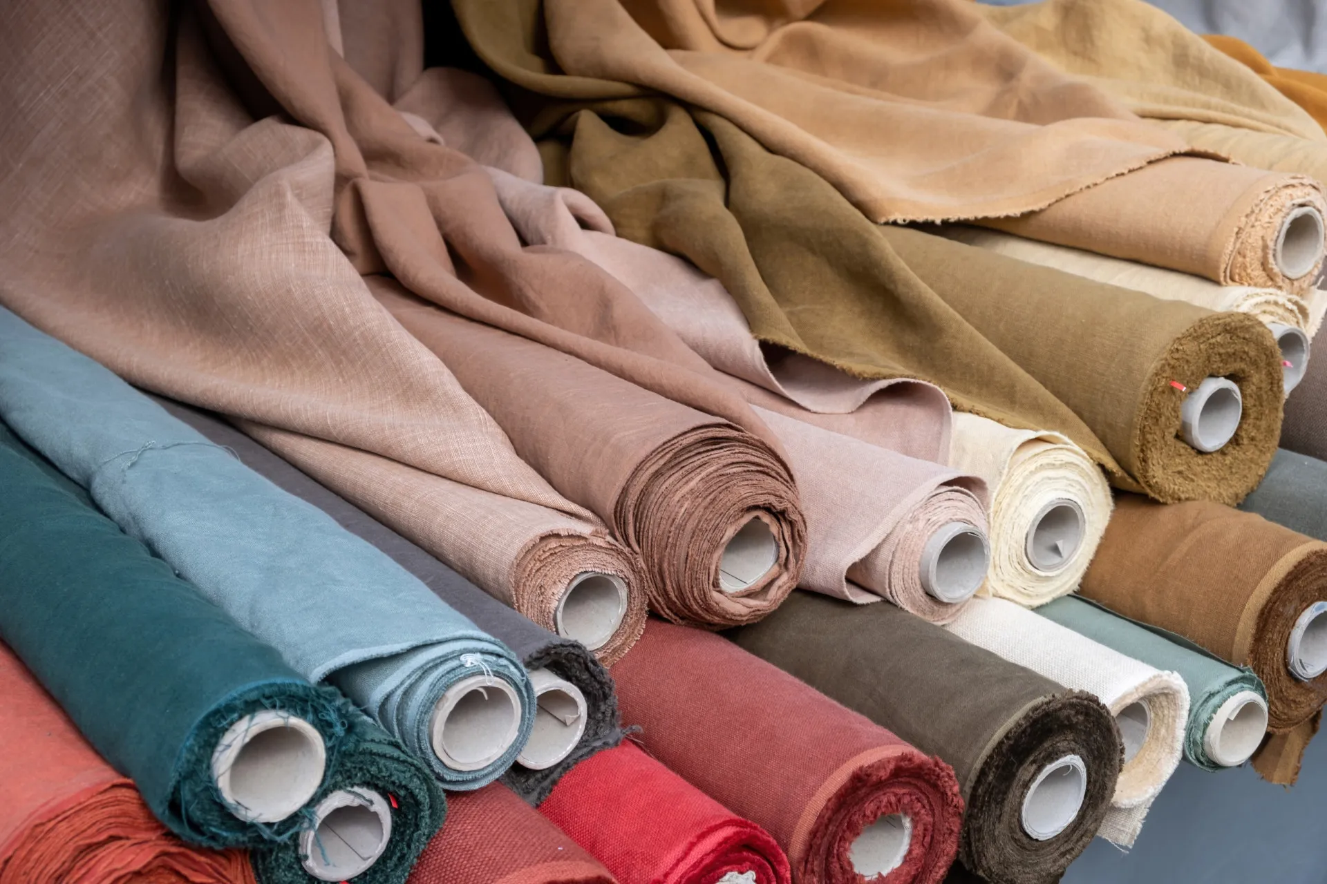 Uma fábrica de roupas com várias máquinas de costura e trabalhadores produzindo peças em massa.