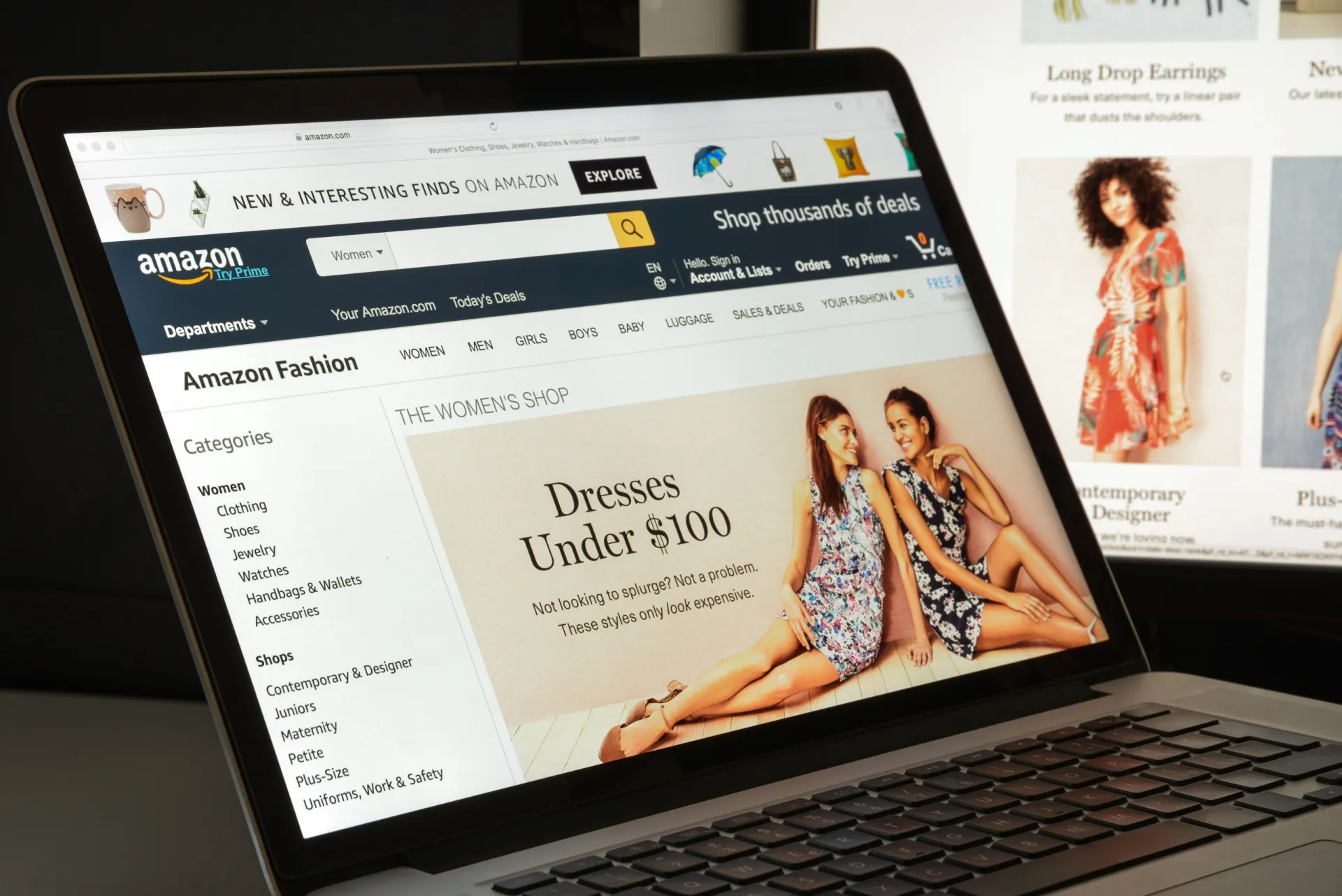 Uma pessoa comprando online em um tablet, com várias sacolas de compras ao lado.
