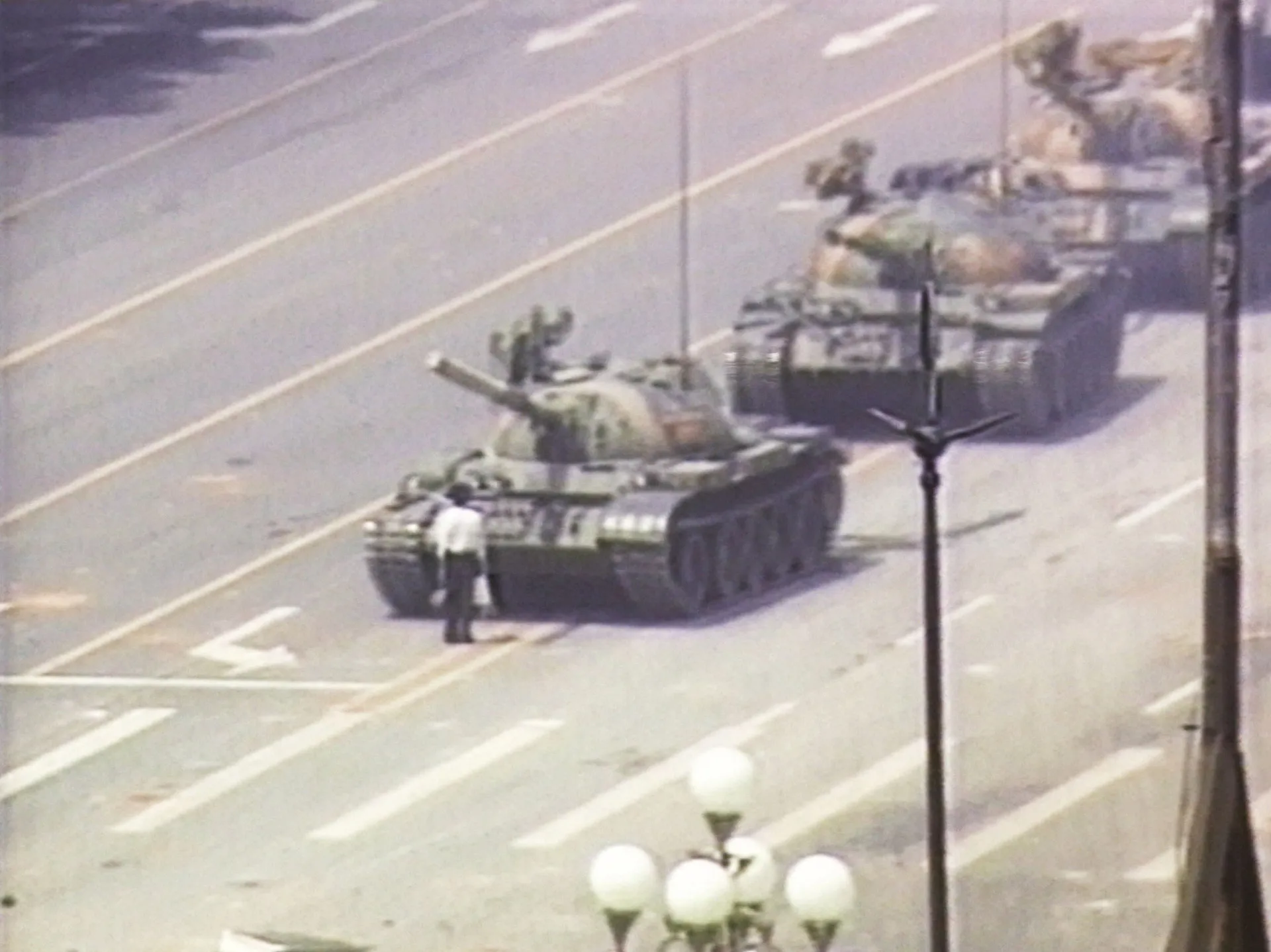 Um homem solitário parado em frente a uma coluna de tanques na Praça da Paz Celestial, em Pequim.