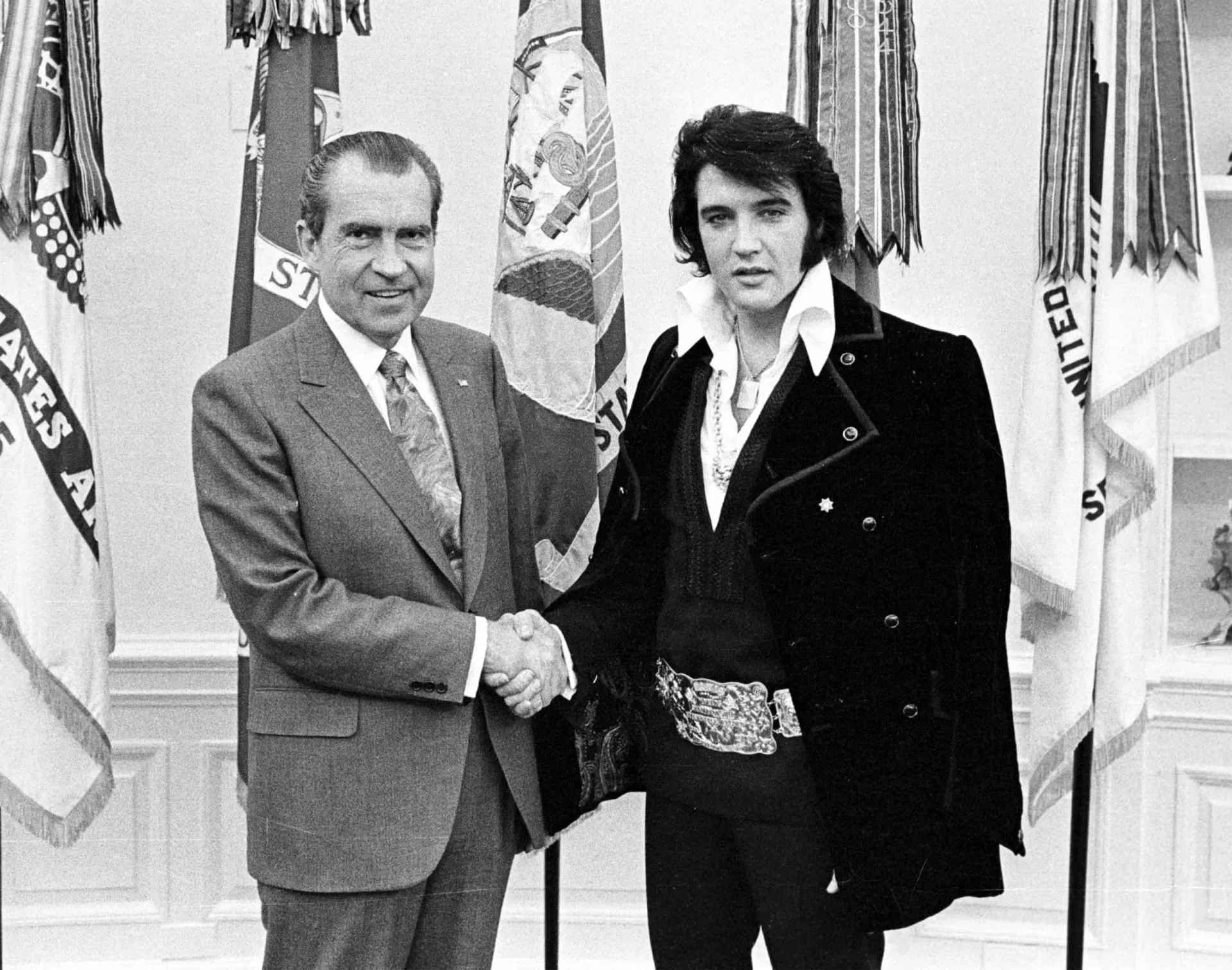 O presidente Richard Nixon apertando a mão de um sorridente Elvis Presley no Salão Oval.