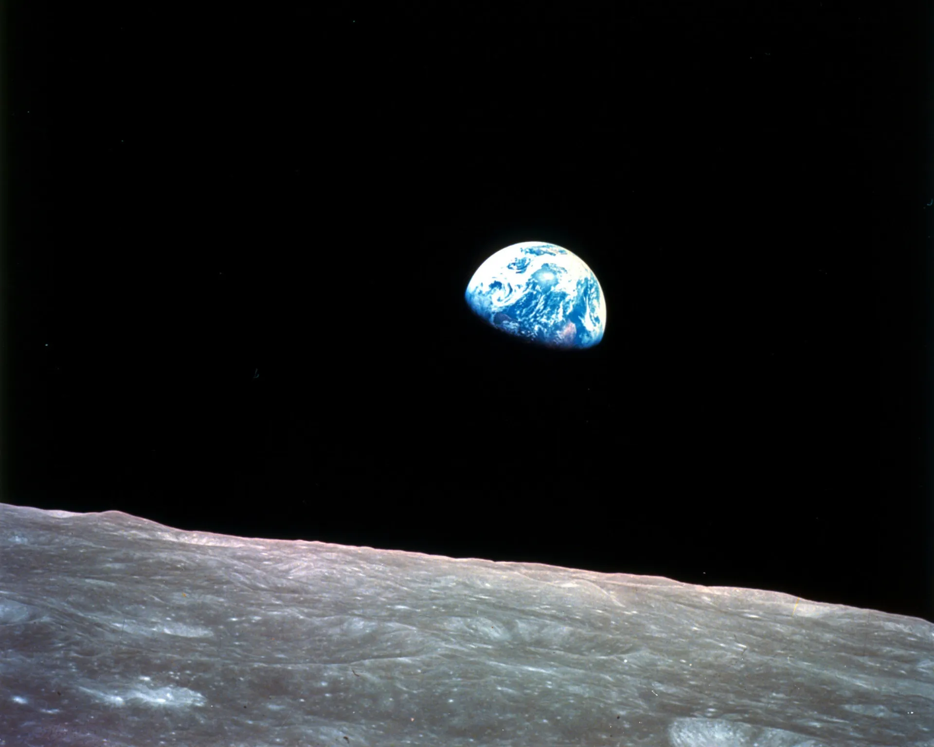 A Terra vista do espaço, parecendo um mármore azul e branco surgindo sobre a superfície da Lua.