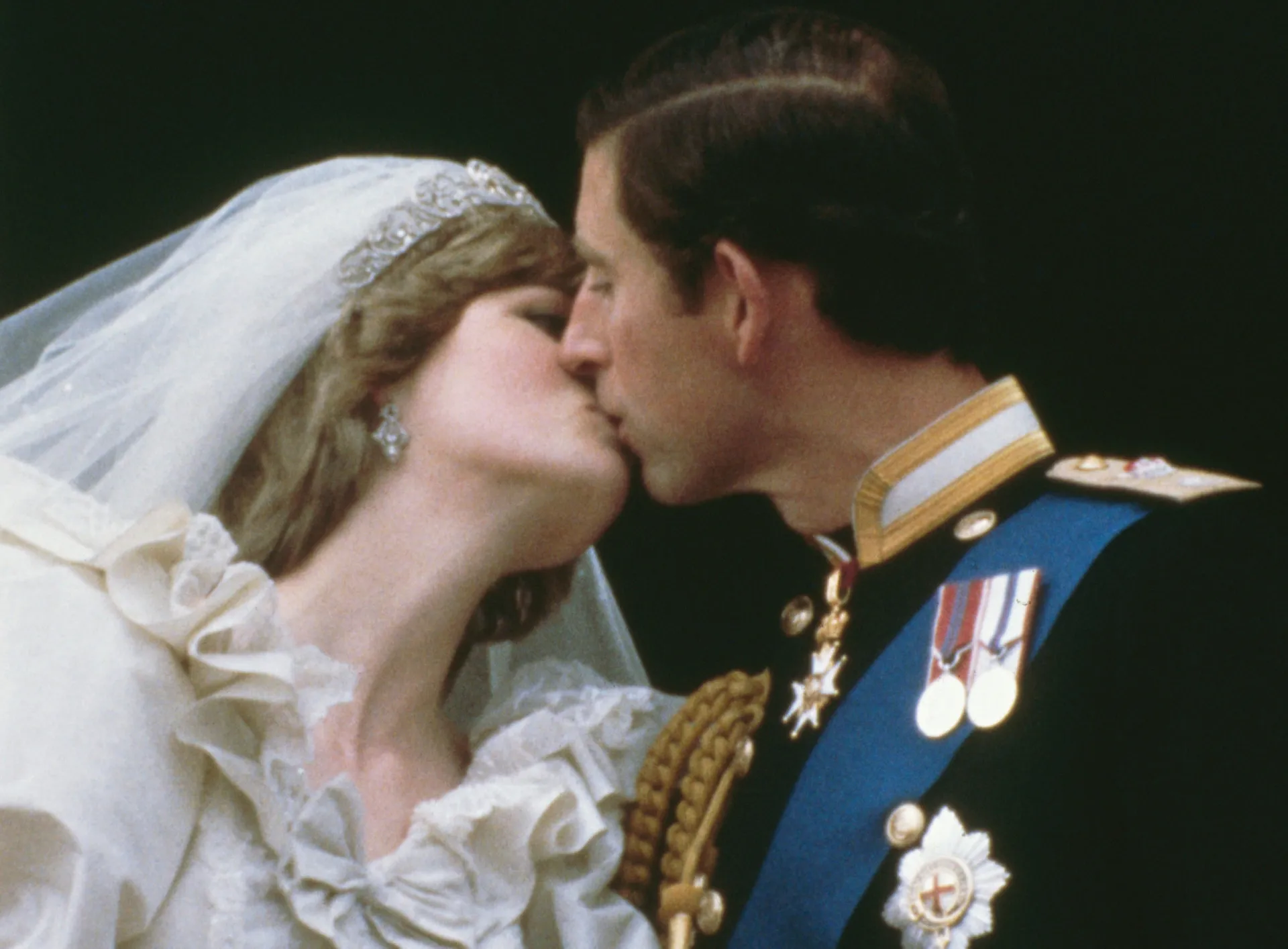Príncipe Charles e Princesa Diana se beijando na varanda do Palácio de Buckingham em seu casamento.