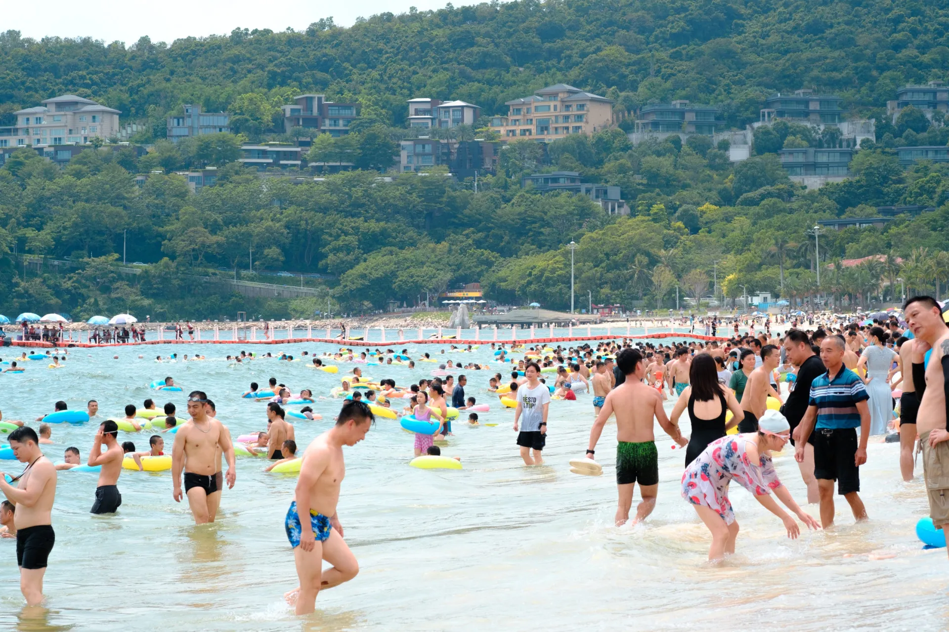 Multidão compacta de pessoas na praia de Shenzhen, China.