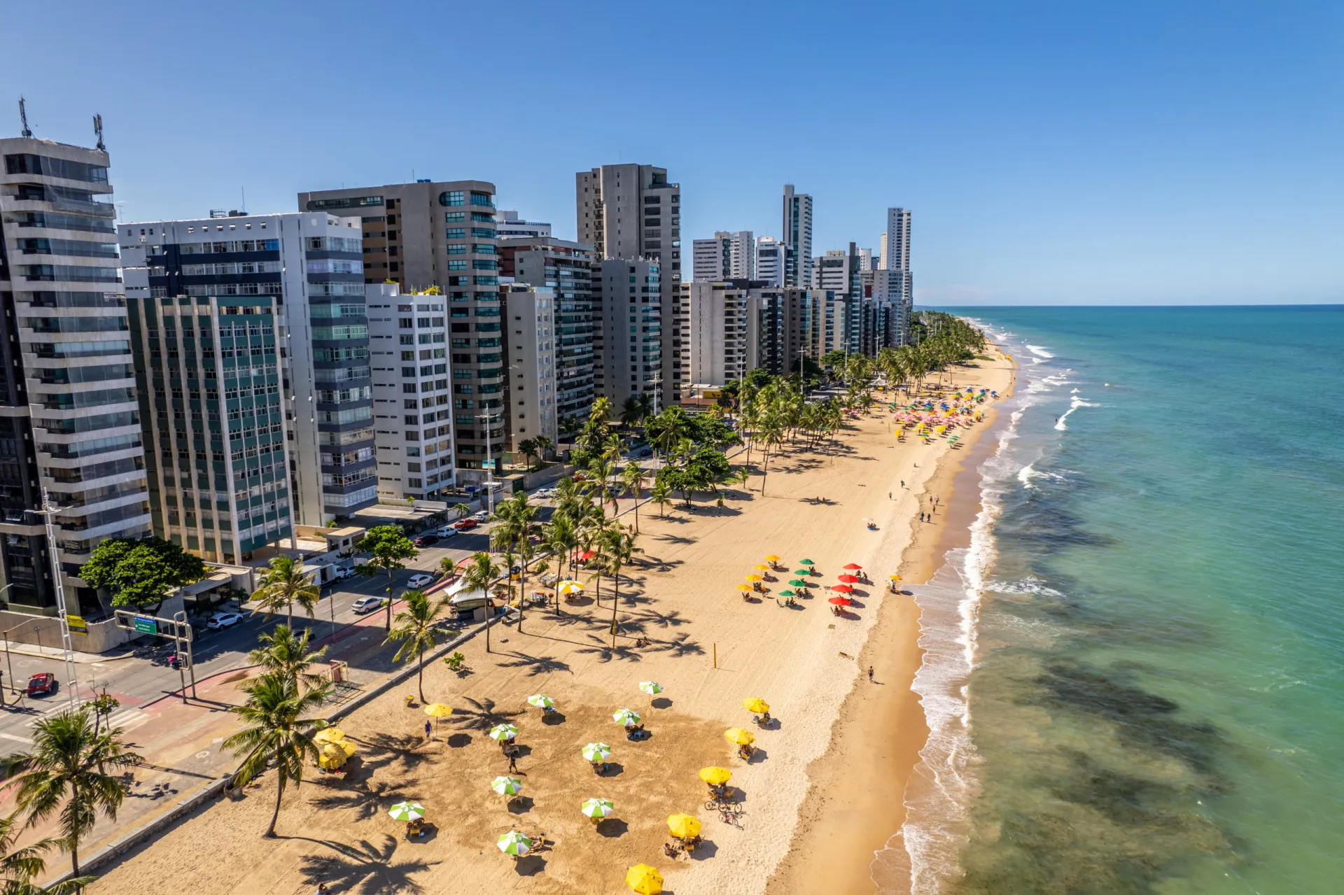 Praia de Boa Viagem em Recife, com prédios ao fundo.