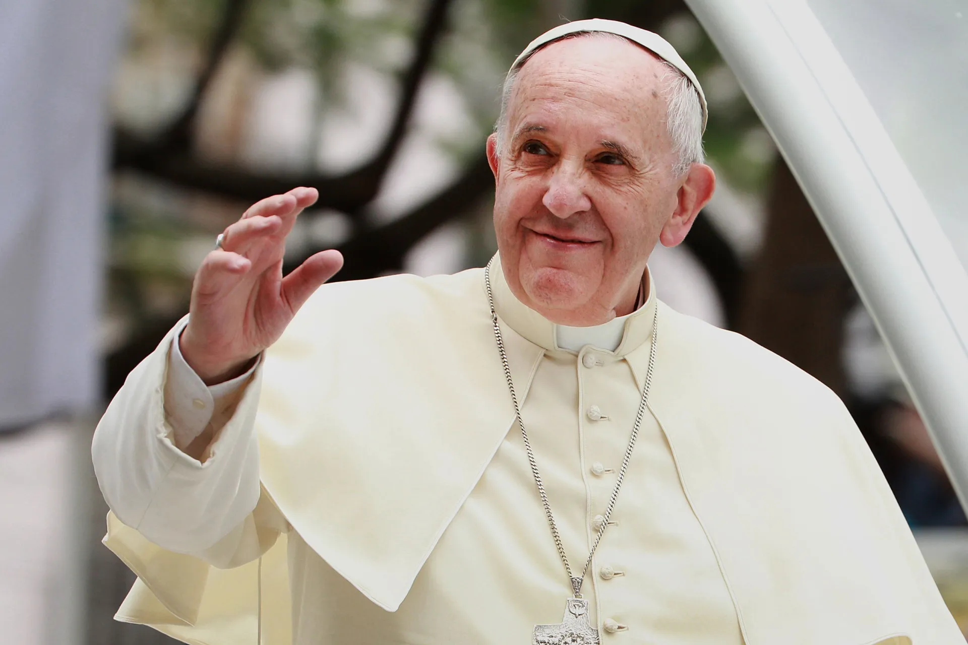 O Papa acenando para uma multidão, simbolizando sua liderança na Igreja Católica.