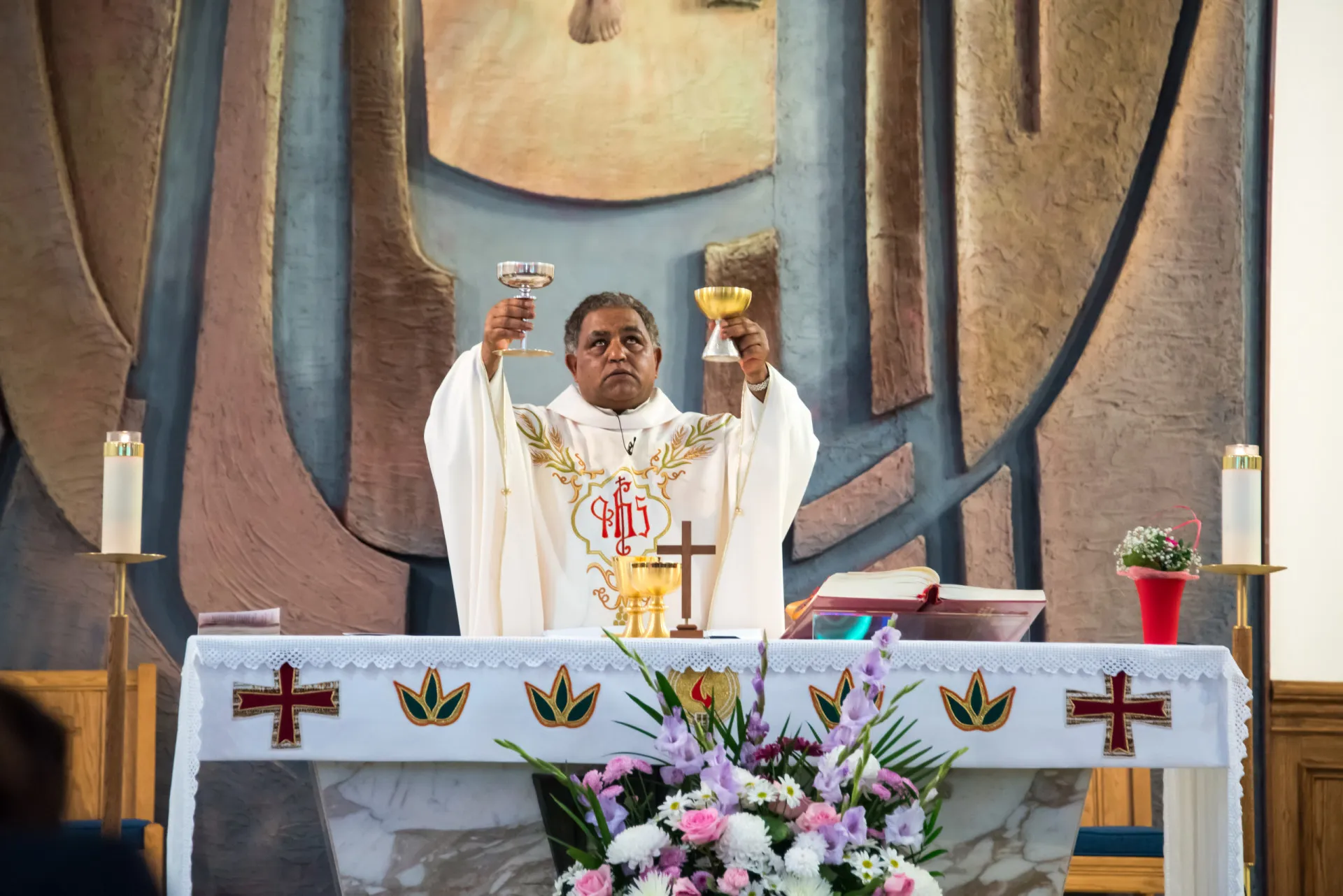 O pão e o vinho da Eucaristia dispostos em um altar durante a missa.