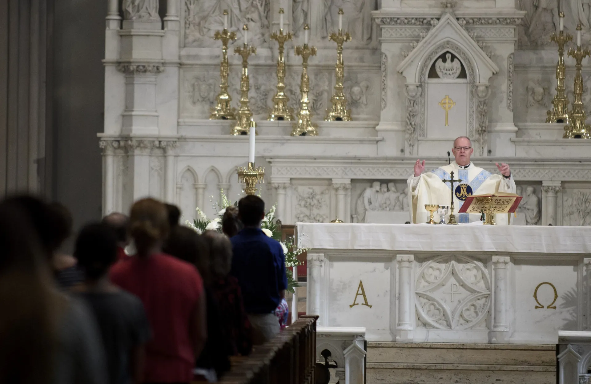 Fiéis reunidos dentro de uma catedral para a missa de domingo.