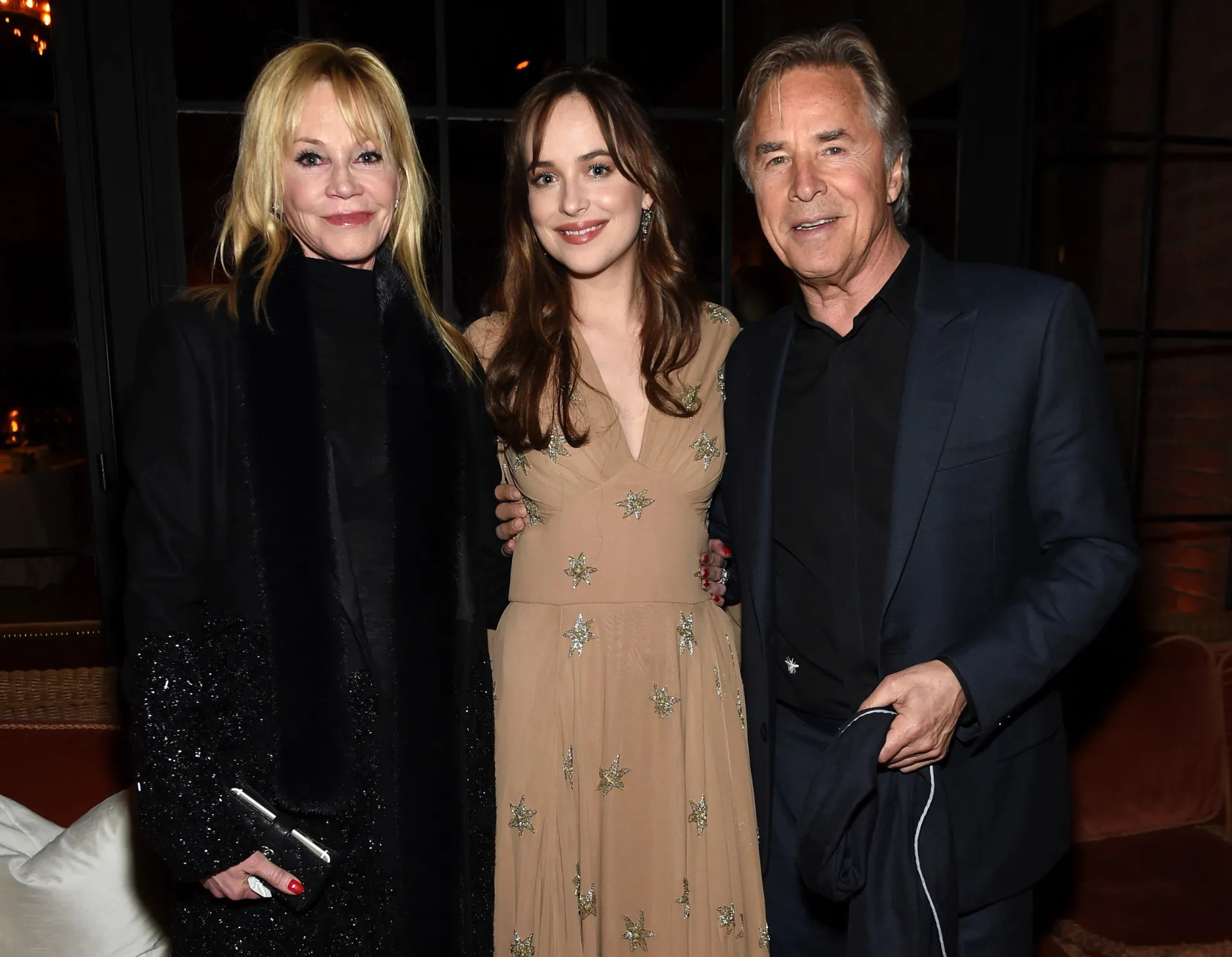 A atriz Dakota Johnson posando em um tapete vermelho.