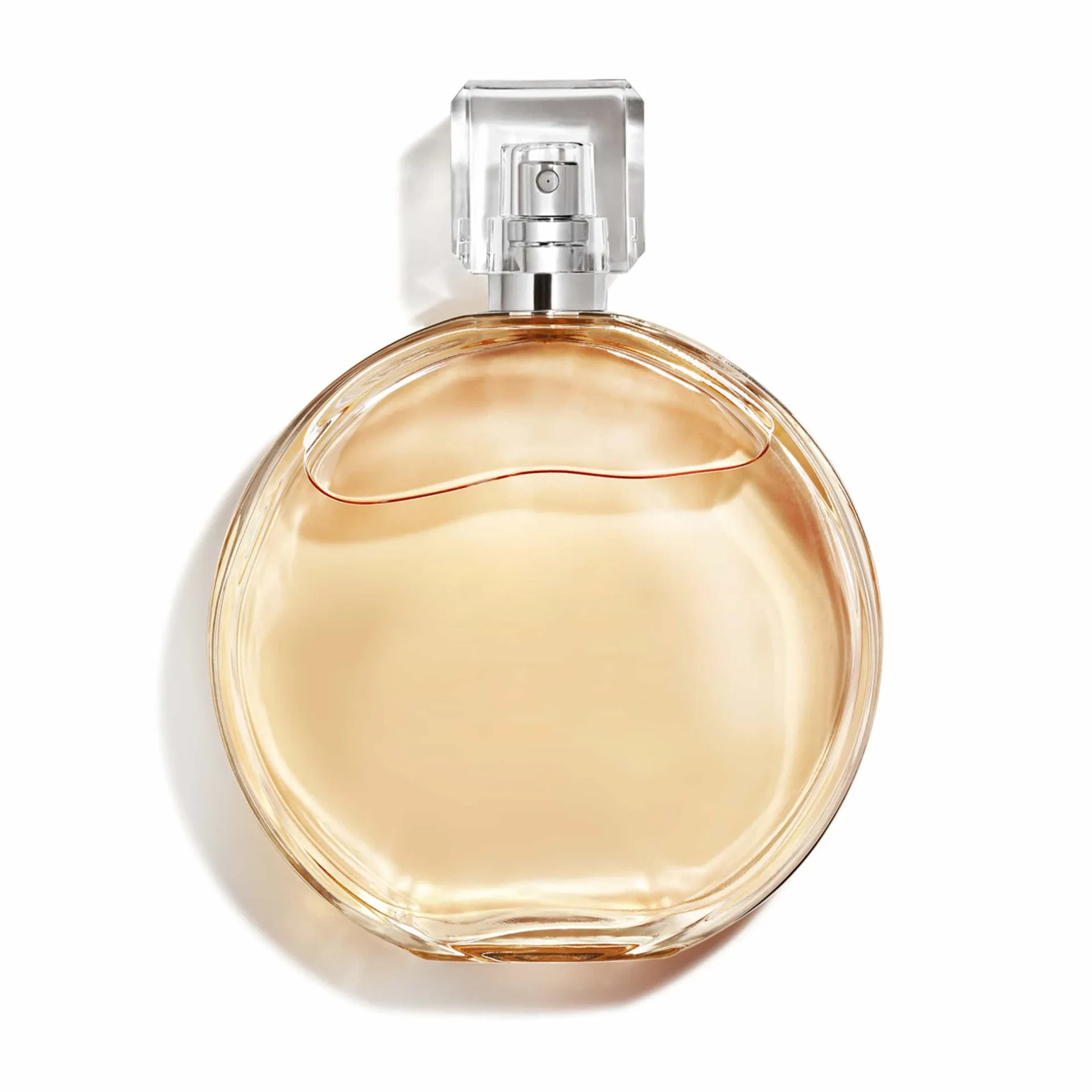 Mulher borrifando perfume em seu pulso, com um brilho dourado ao redor.