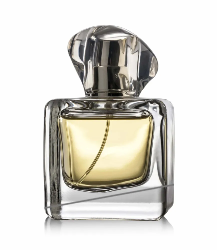 Frasco de perfume minimalista cercado por flores brancas e delicadas.