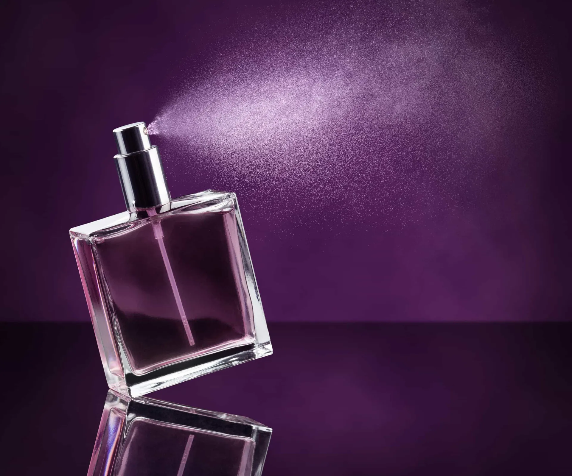 Frasco de perfume luxuoso com notas de chocolate e especiarias ao redor.