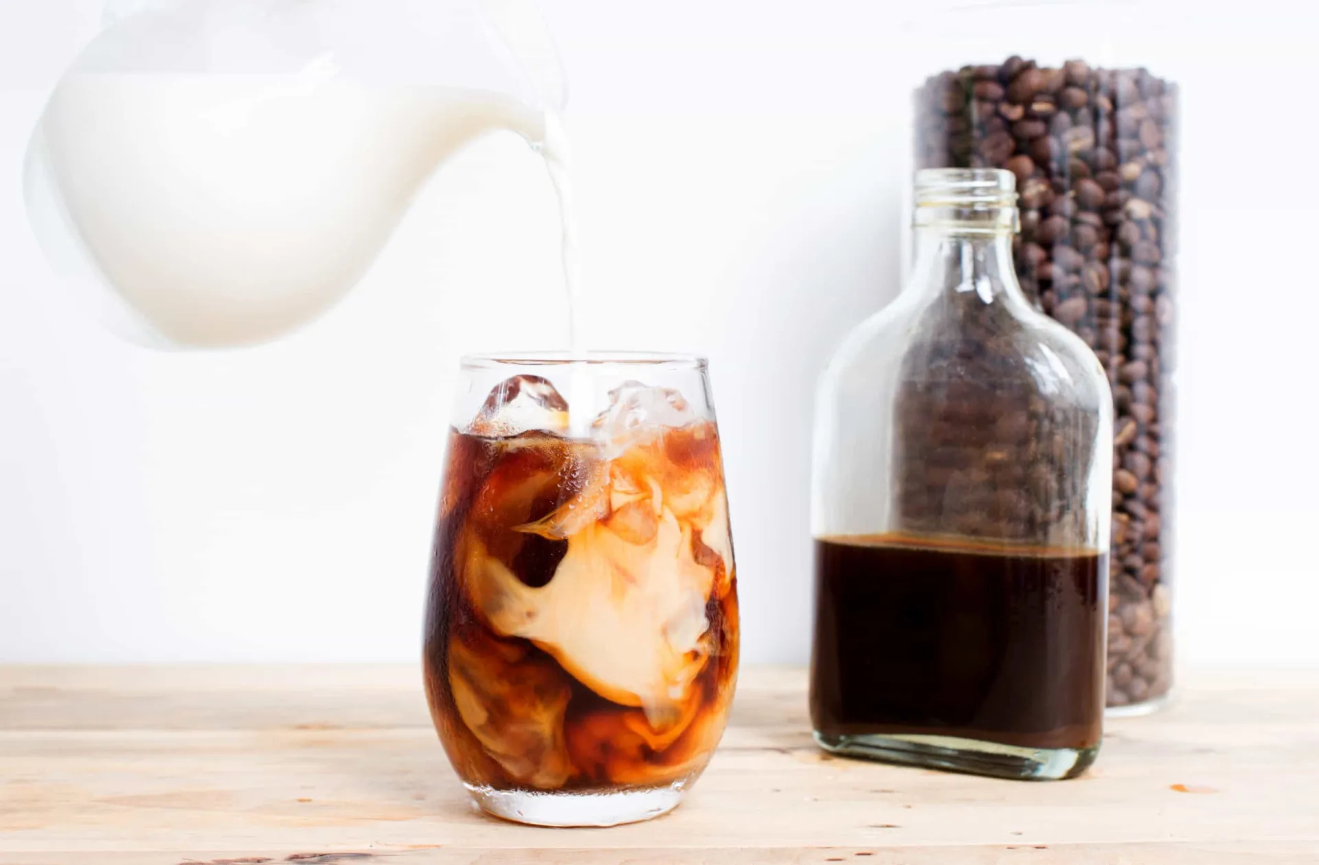 Copo de café frio com gelo e leite, criando um efeito visual de camadas.