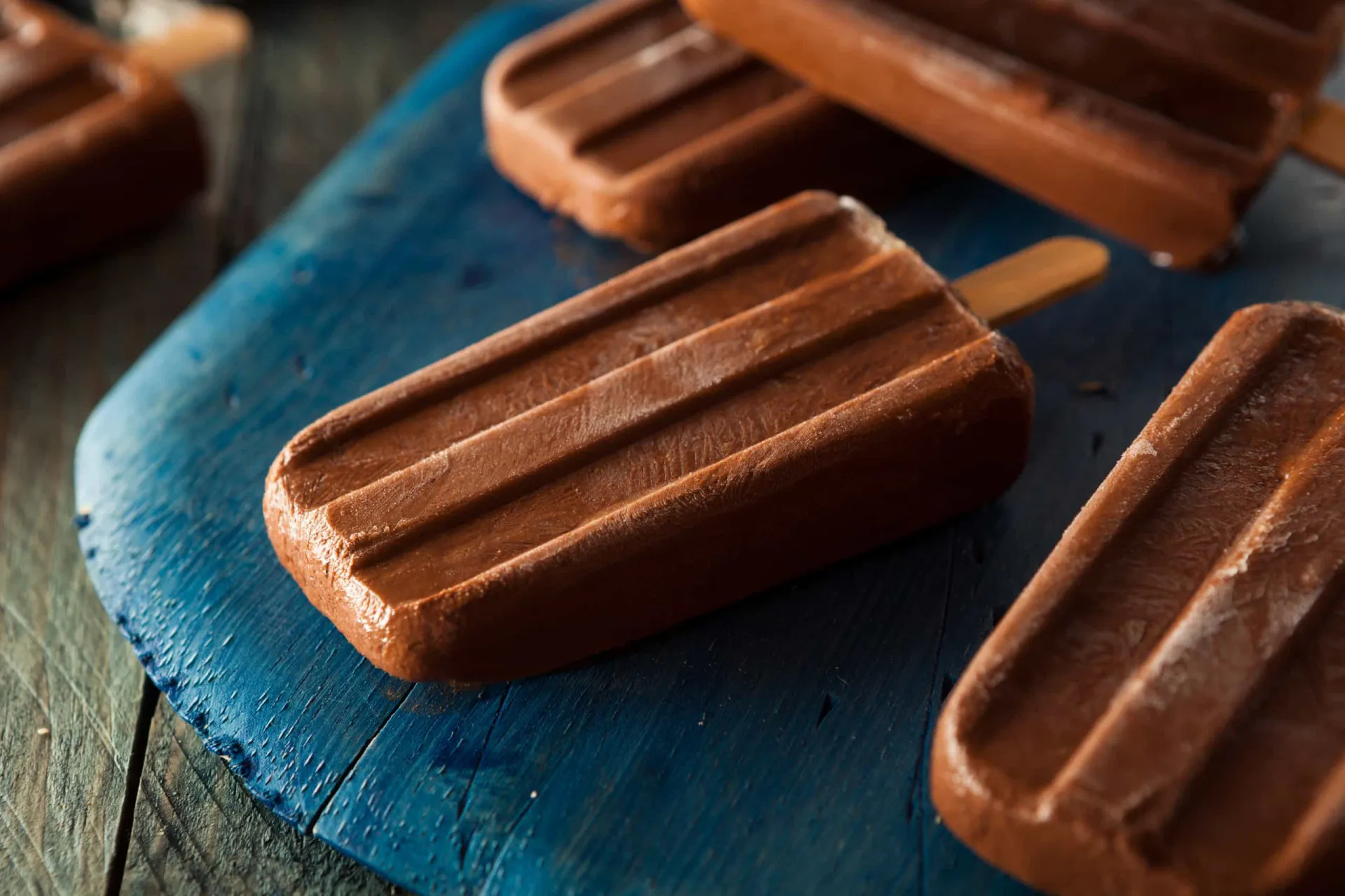 Picolés de chocolate cremosos e escuros, recém-saídos das forminhas.
