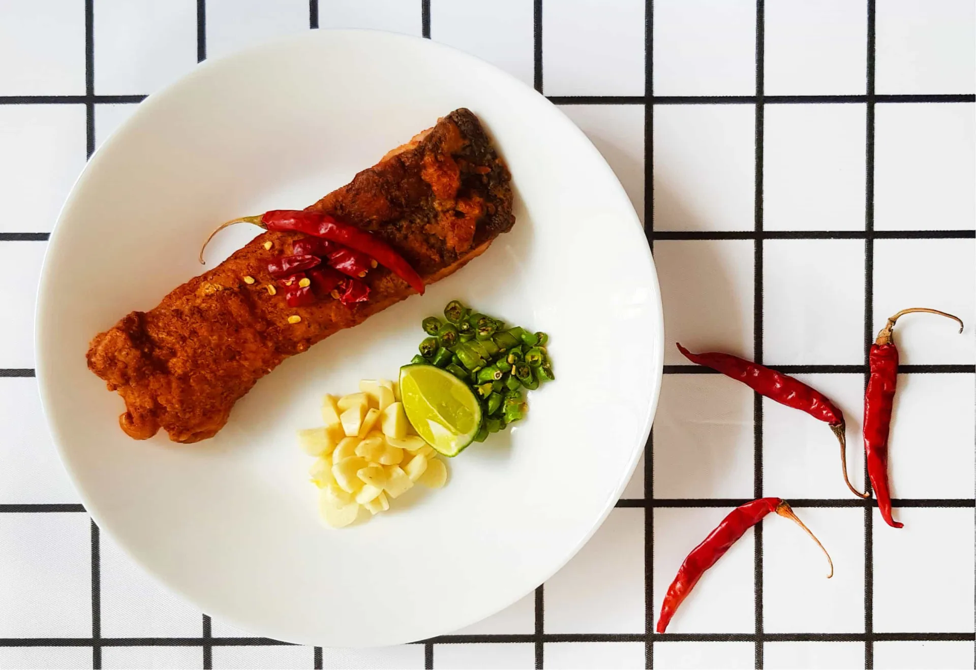 Filé de salmão assado com uma cobertura agridoce de pimenta e cebolinha picada.