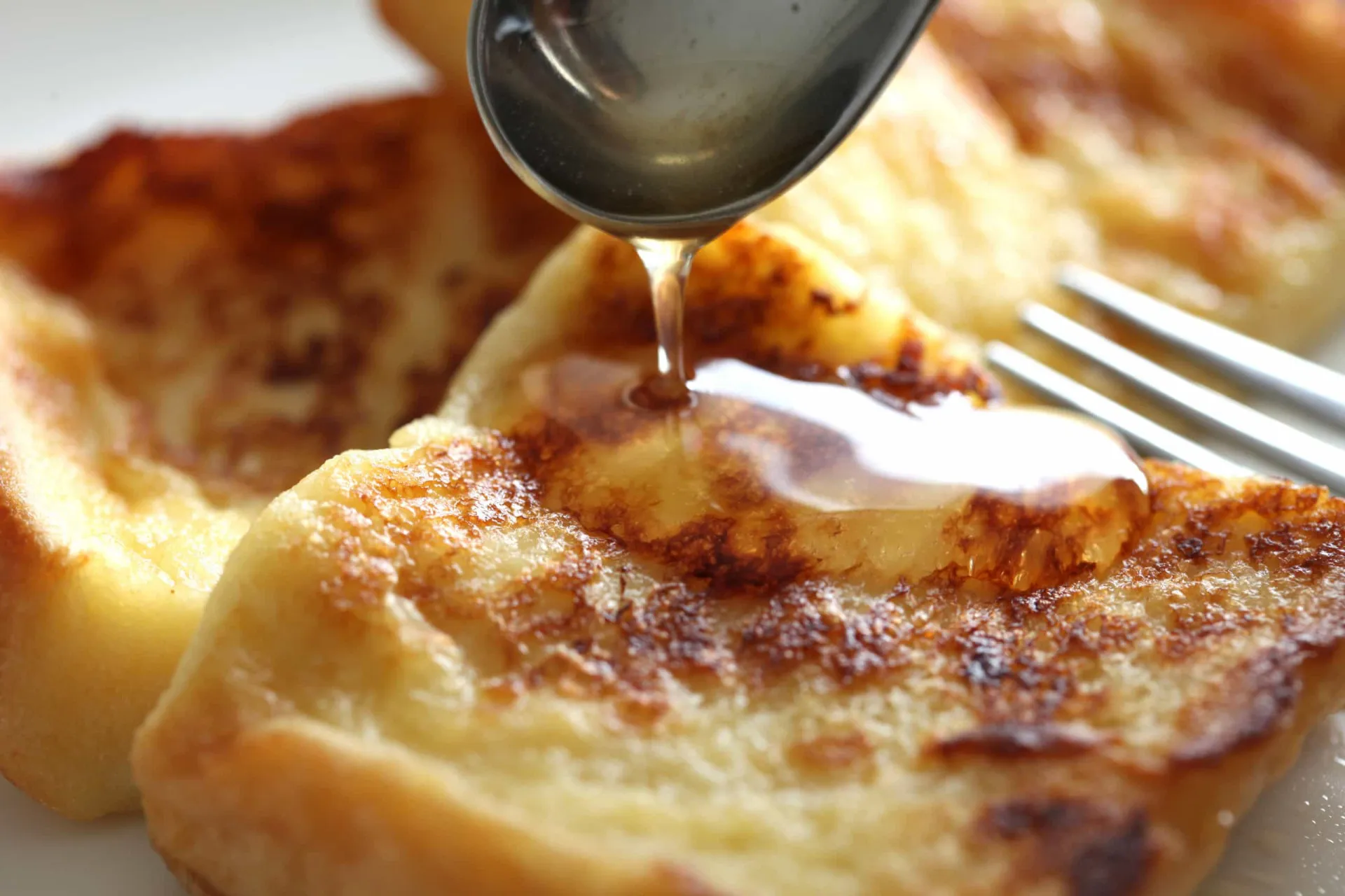Fatias grossas de rabanada dourada e caramelizada, feitas com brioche e sorvete.