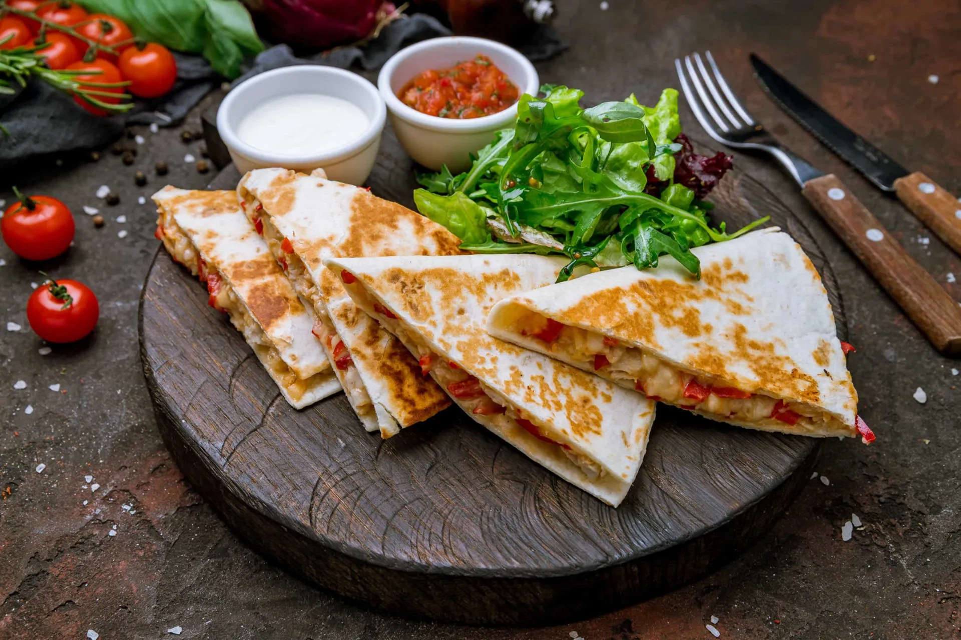Quesadilla dourada cortada em triângulos, com o queijo derretido escorrendo pelas bordas.