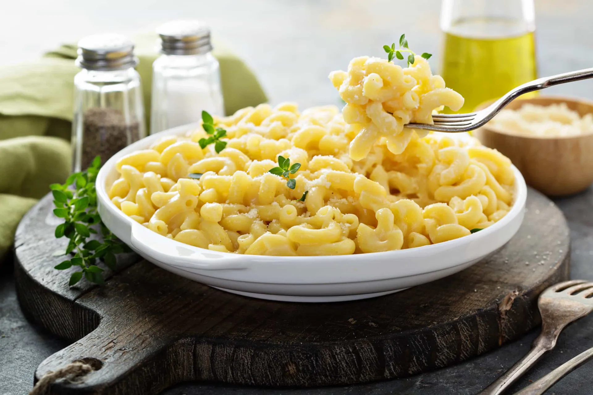 Uma tigela de macarrão com queijo super cremoso e borbulhante, com uma colher dentro.