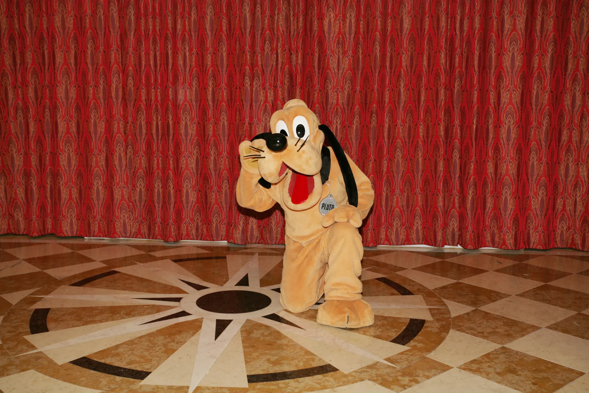 Personagem Pluto em uma fonte, simbolizando o local onde a funcionária foi empurrada.