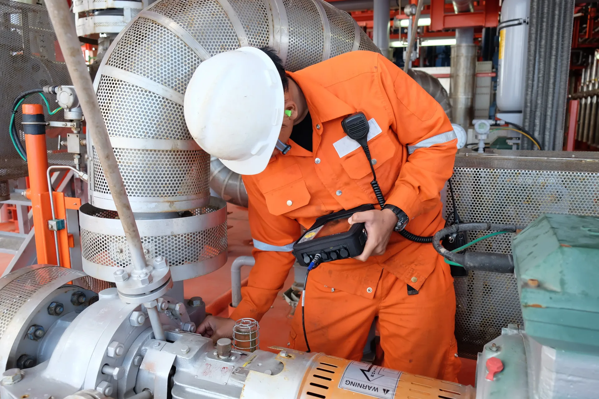 Dois engenheiros analisando o projeto de um motor em um ambiente industrial.